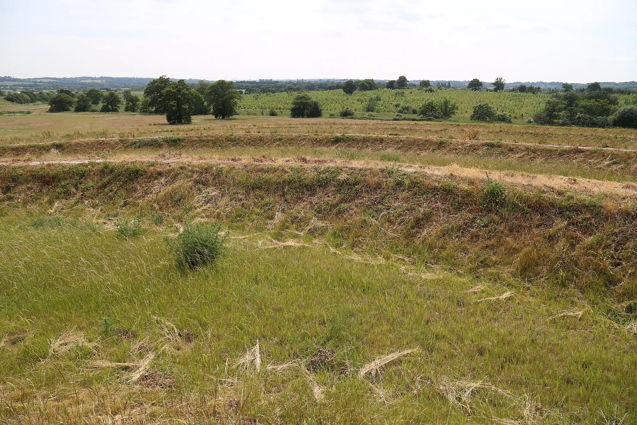 Photo showing: Looking south-west from an earthwork art sculpture of concentric rings by landscape artist Richard Harris at Theydon Bois Woodland Trust 222 acre wood on Abridge Road, Theydon Bois, Essex, England. The earthwork is directly at the west side of the M11 motorway, south of its junction with the M25. Between the raised chalk walkways will be planted British native trees.