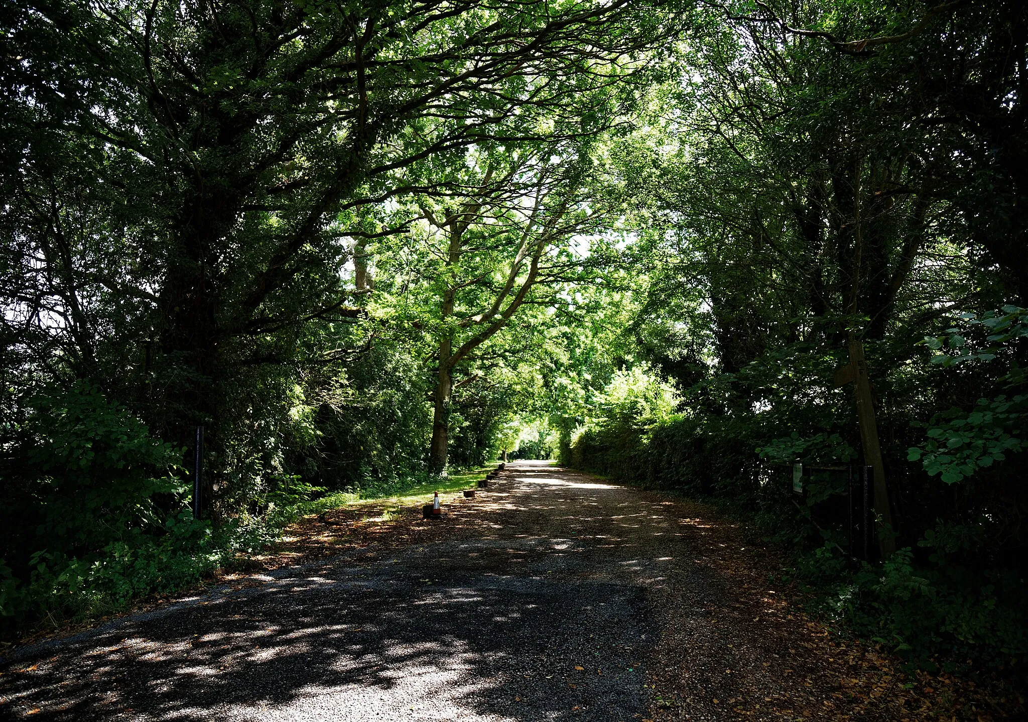 Photo showing: An entrance and driveway in dappled light in the parish of Hatfield Broad Oak, in Essex, England. Mobile device view: Wikimedia (June 2020) makes it difficult to immediately view photo groups related to this image. To see its most relevant allied photos, click on Hatfield Broad Oak, and this uploader's Photos. You can add a click-through 'categories' button to the very bottom of photo-pages you view by going to settings... three-bar icon top left. Desktop view: Wikimedia (June 2020) makes it difficult to immediately view the helpful category links where you can find images related to this one in a variety of ways; for these go to the very bottom of the page. This image is one of a series of date and/or subject allied consecutive photographs kept in progression or location by file name number and/or time marking. Camera: Canon EOS 6D Mark II with Canon EF 24-105mm F4L IS USM lens. Software: File lens-corrected, optimized, perhaps cropped, with DxO OpticsPro Elite, and likely further optimized with Adobe Photoshop CS2.