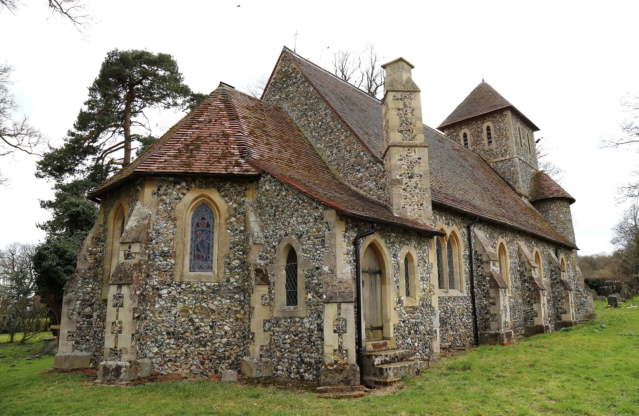 Photo showing: St John the Evangelist's Church, Bush End, Hatfield Broad Oak, Essex, England ~ buttressed chancel and nave, and vestry with attached chimney stack at the north of the chancel