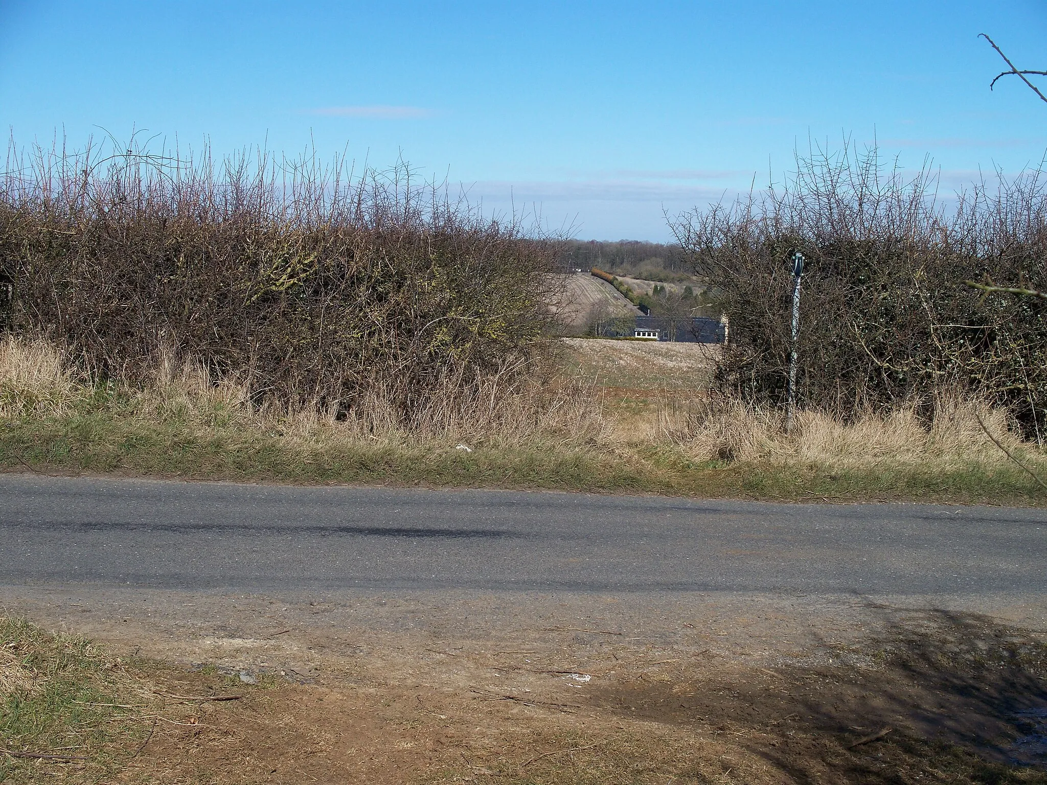 Photo showing: Crossing of a bridleway and a minor road near Lidstone, Oxfordshire. The roof visible through the gap in the hedge is that of Lidstone Court.