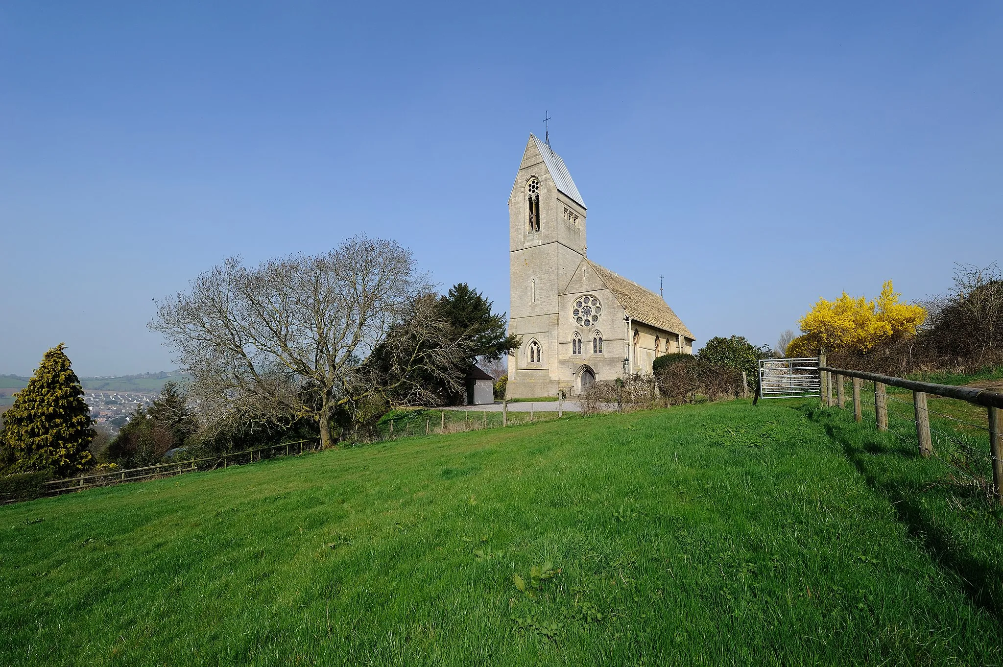 Photo showing: All Saints Church is the parish church for Selsley in Gloucestershire. Construction took place in 1861-62. The church contains William Morris's first commission for ecclesiastical stained glass. The distinctive saddleback tower is over a hundred feet easily catching the changing Cotswolds light on its French Gothic gables: the last of the great Cotswold wool churches, and the first to exhibit work of the English Arts and Craft movement. The church is Grade 1 listed by English Heritage who says that this church is one of George Frederick Bodley's most important early works and of great significance in the development of High Victorian architecture.