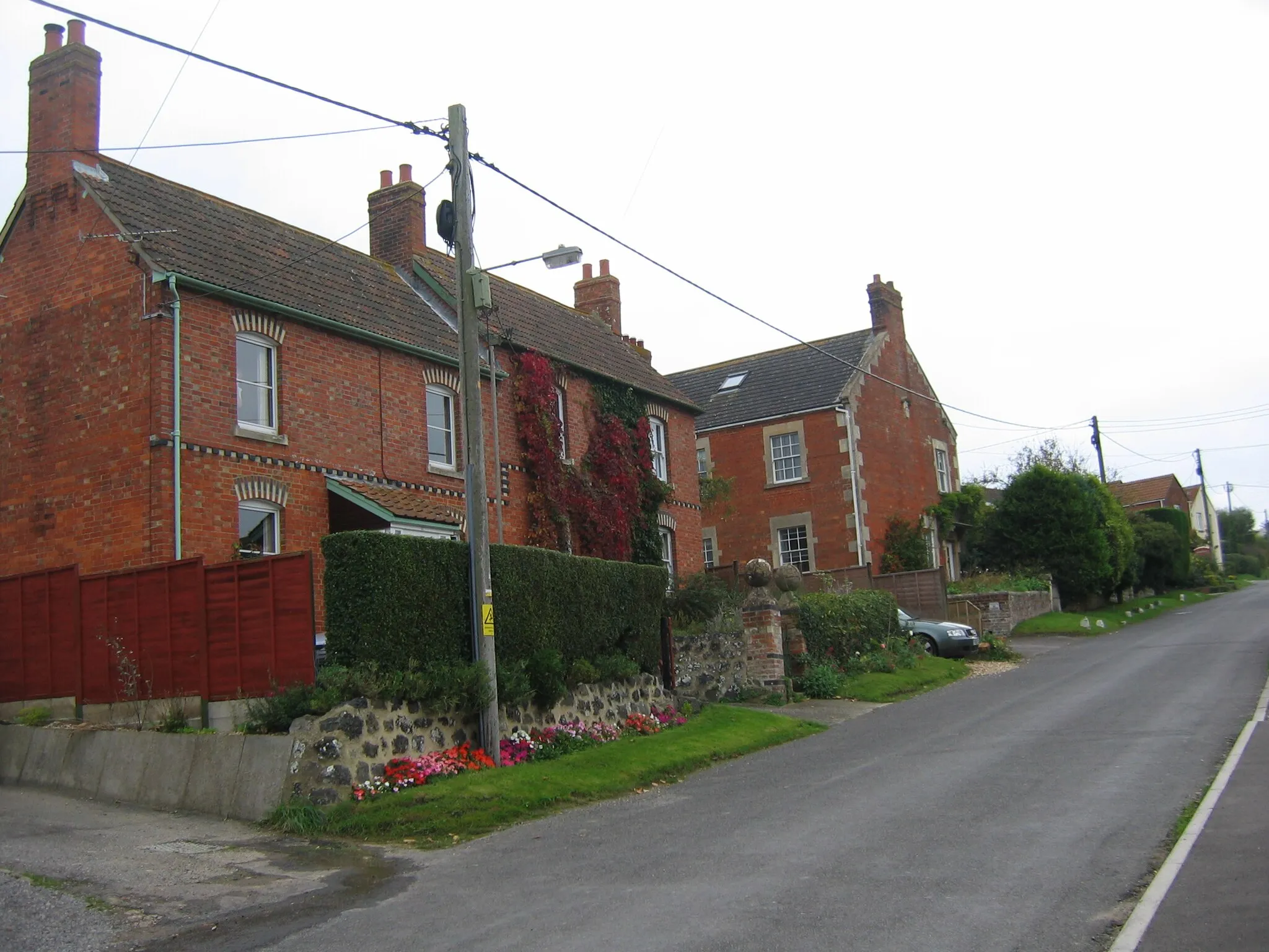 Photo showing: Main road of Seend Cleeve, with the village's only red telephone box visible in the background.