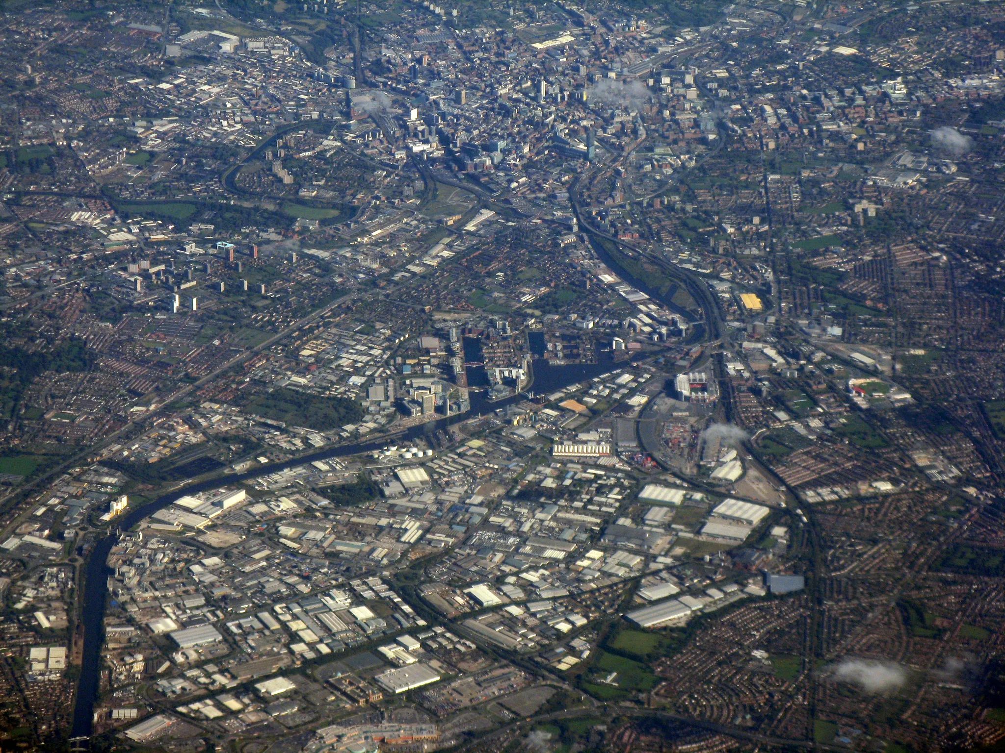 Photo showing: An aerial photograph of Manchester city centre (running along the top of the image), Salford (left half of the image) and Trafford (right half of the image), all of which are in Greater Manchester, England.

Landmarks such as the bend in the River Irwell by Salford University, the Beetham Tower in Manchester city centre and Old Trafford in Stretford are all in this image. The docks of Salford Quays occupy the centre-part of this photograph.