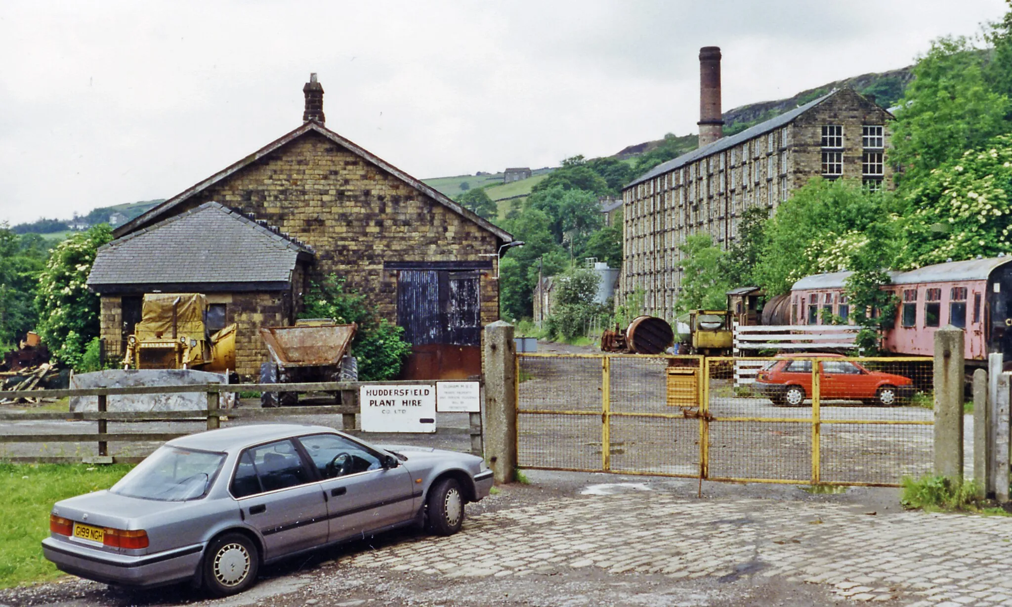 Photo showing: Delph station (remains), 1996.
View SW, towards Greenfield: ex-LNWR terminus of short branch from Greenfield. The branch was closed to Passengers 2/5/55, to goods 4/11/63 - but it looks as if some track remains over 30 years later. (My Honda Accord is prominent).