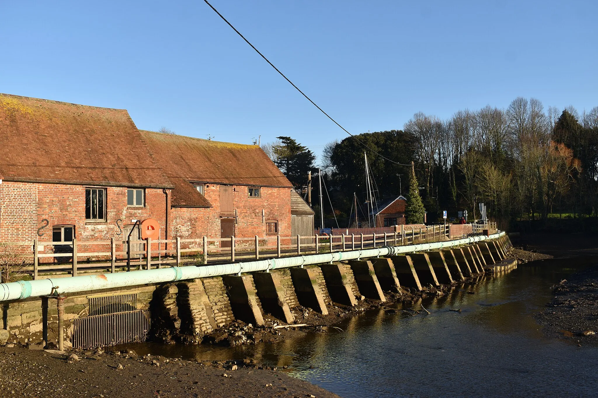Photo showing: Eling Causeway seen from the adjacent picnic area in Hampshire, England. Also visible to the left is the old Eling Tide Mill.