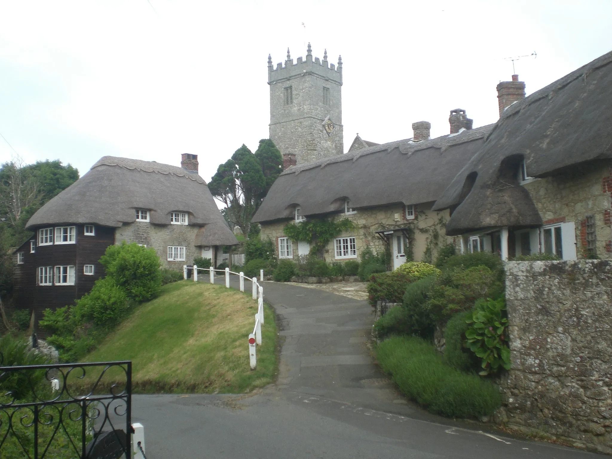 Photo showing: Church Hill, Godshill, Isle of Wight, with the tower of All Saints parish church behind the thatched cottages