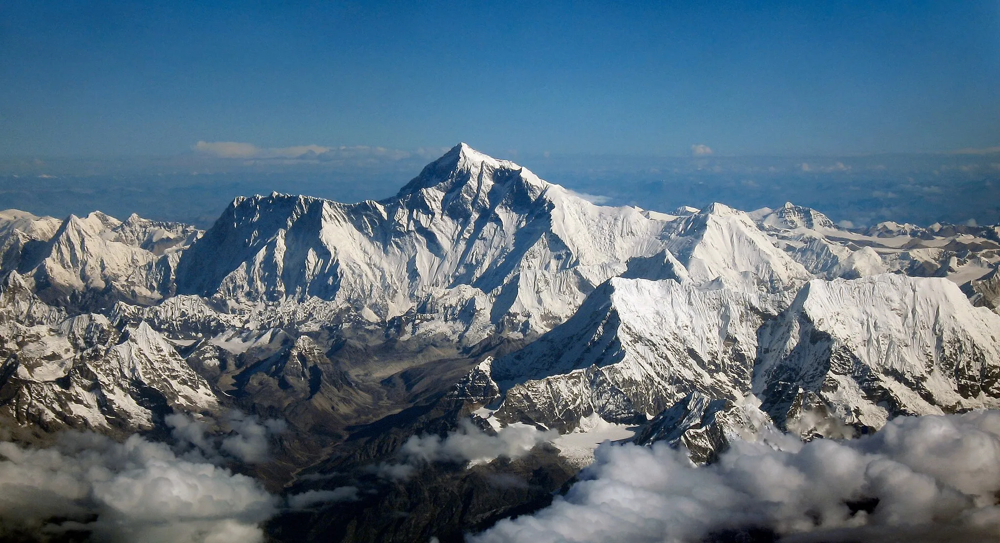 Photo showing: View northward of Mount Everest from an aircraft from airline company Drukair in Bhutan. The aircraft is south of the mountains, directed north. Mount Everest is above the ridge connecting Nuptse and Lhotse.