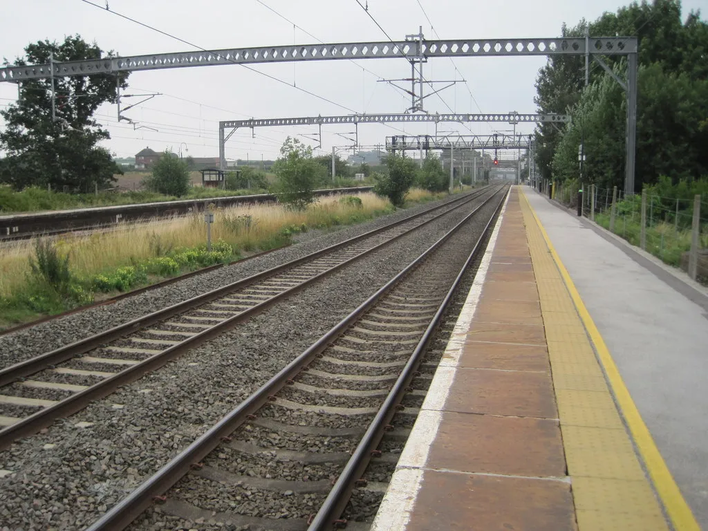 Photo showing: Polesworth station: Opened in 1847 by the London & North Western Railway on the line from Rugby to Stafford, this station was reduced to just one northbound service per day when this image was taken. 
View south east towards Atherstone and Rugby. There was no access to the southbound platform (left) which was consequently overgrown! A platform shelter can be seen in the undergrowth - which was actually the only shelter on the whole station.