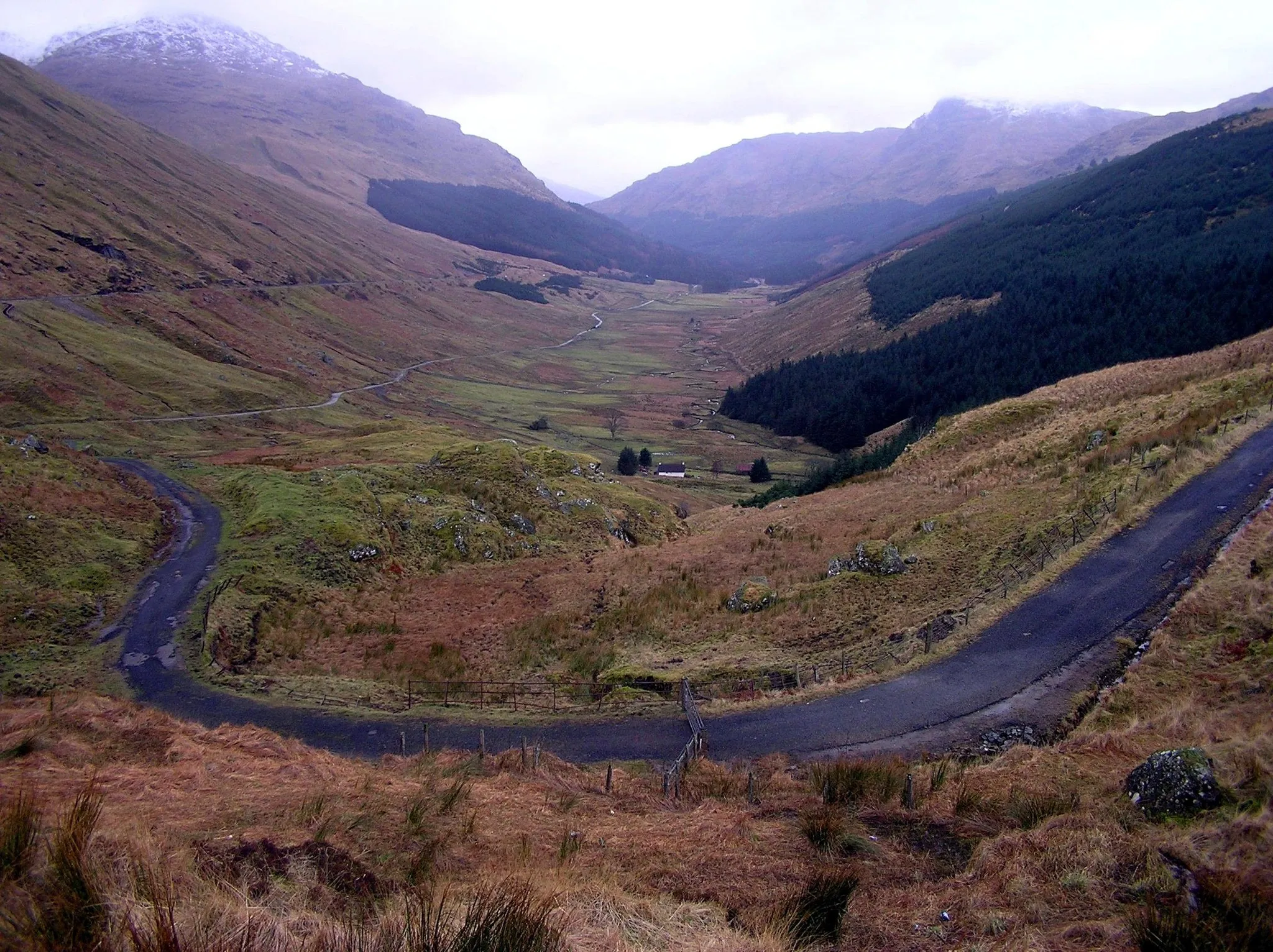 Photo showing: Glen Croe, Scotland. Viewed from 'Rest and Be Thankful' Car Park on the A83. The A83, Ardgartan to Inveraray road is seen passing along the left of the picture above the old drovers road in the valley bottom.