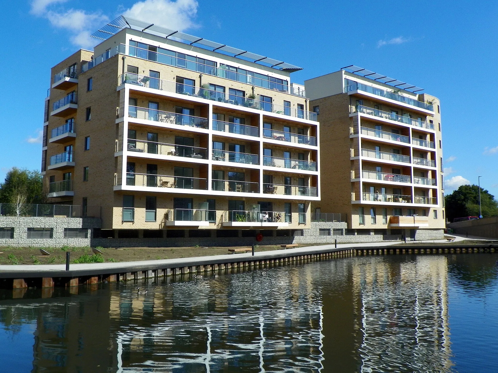 Photo showing: Copper Court (and one I can't name), Essex Wharf, Clapton, Hackney, London E5. These appartments were being built when we did the walk in February, but were completed by September. This development was controversial!

GOC Hertfordshire's walk on 19 September 2015, which was a repeat of the February 2015 walk when I did not take my camera. It went from Walthamstow to Stratford via Lea Bridge and Victoria Park, all in London. John T was the walk leader and it was 9.1 miles. Please check out the other photos from the walk here, or to see my collections, go here. For more information on the Gay Outdoor Club, see www.goc.org.uk.