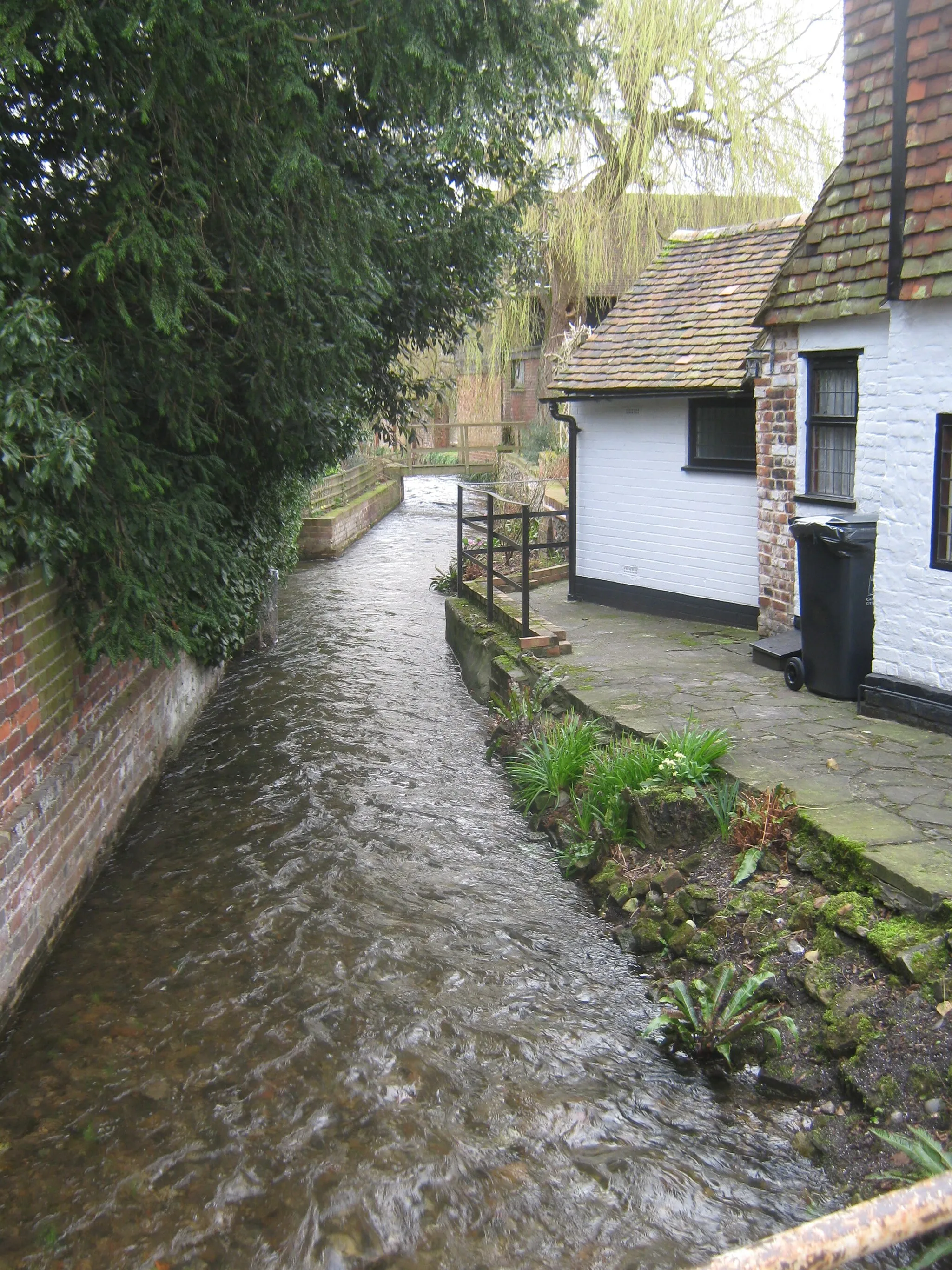 Photo showing: The Nailbourne Stream in Bridge As seen from Bridge High Street. This stream is an intermittent stream flowing for about 6 months every 5-7 years. But in the Winter of 2000/2001 it flowed more strongly than any previous records were held. It flooded many nearby cottages and houses along its route. Looking upstream.
Currently, it is at full spate due to recent snow melt going through the chalk downs and feeding the springs feeding the stream.