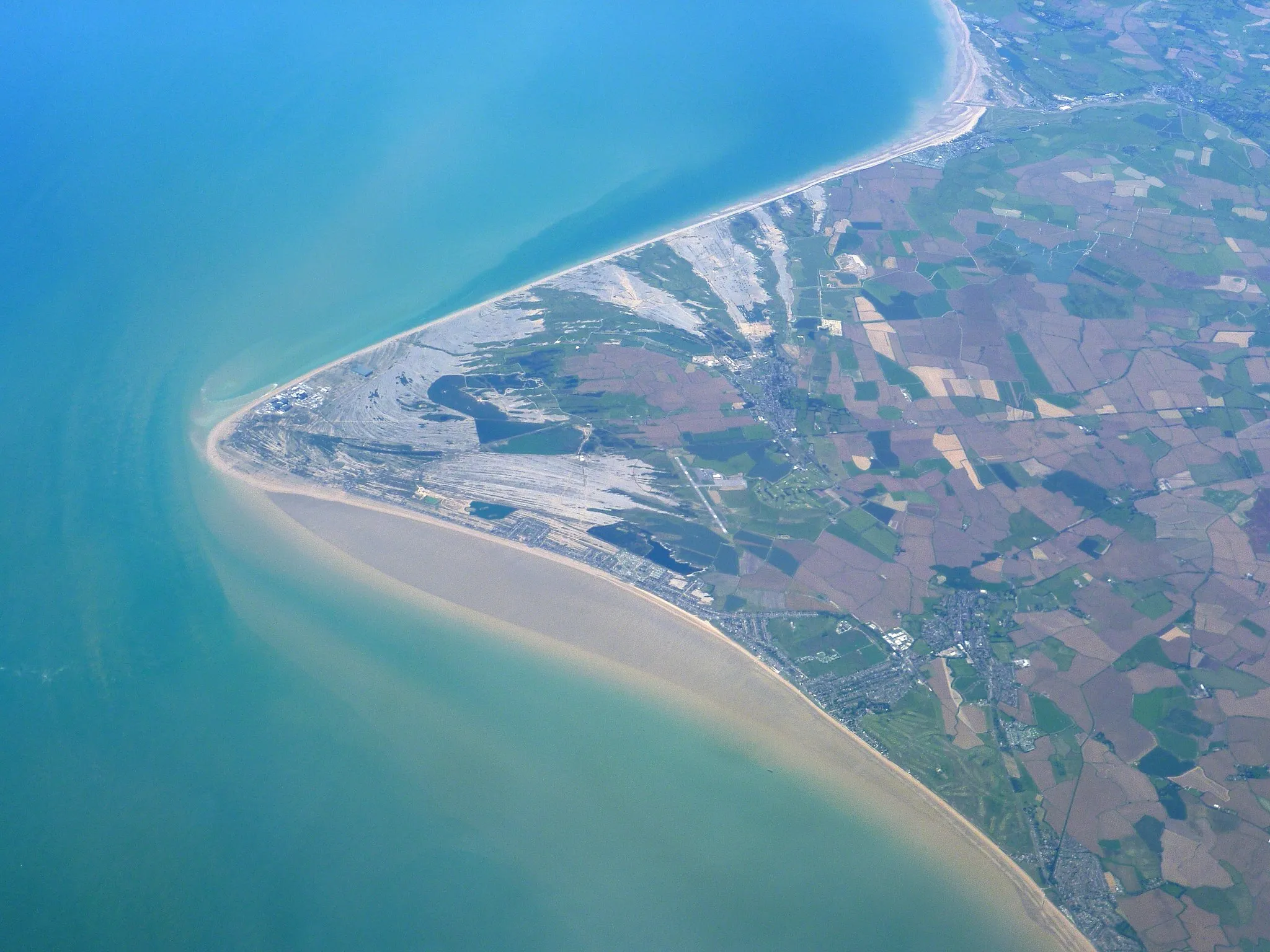 Photo showing: Aerial view of Dungeness. Lydd Airport can be seen more or less in the centre of the photograph with the town beyond, slightly to the right.