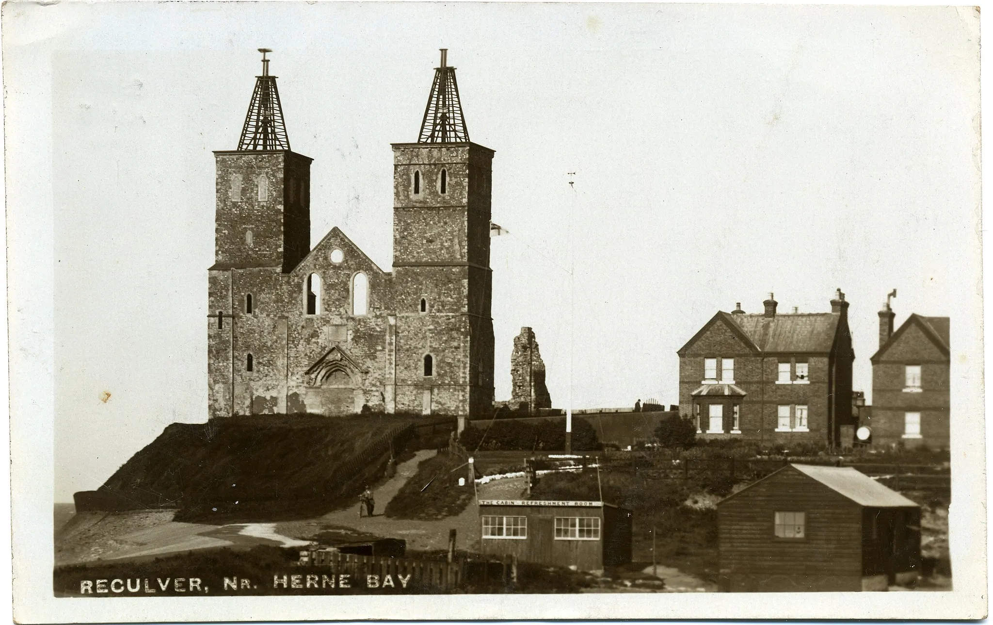 Photo showing: Postcard photo of Reculver Towers, near Herne Bay, Kent England. The photographer was Fred C. Palmer of Tower Studio, Herne Bay, Kent, who died in Hungerford, Berkshire, on 14 March 1941. The postcard is postmarked 6th August 1913.

Border
The remaining border of this image is important for researchers of this photographer. Some photographers trimmed their images more than others, and Palmer has a reputation for producing smaller postcards than other early 20th century UK photographers. He took his own photos, developed them in-house onto postcard-backed photographic paper and trimmed them himself. It is worth adding that during hand-developing the border is actively masked with equipment which both crops the picture and causes the white frame or border to appear on the paper. This frame is part of the design and is one of the reasons why the quality of Palmer's work is so interesting, and why there is an article and category for him on English Wiki. Researchers need to see exactly where the edge of the postcard is. Thank you for taking the time to read this.