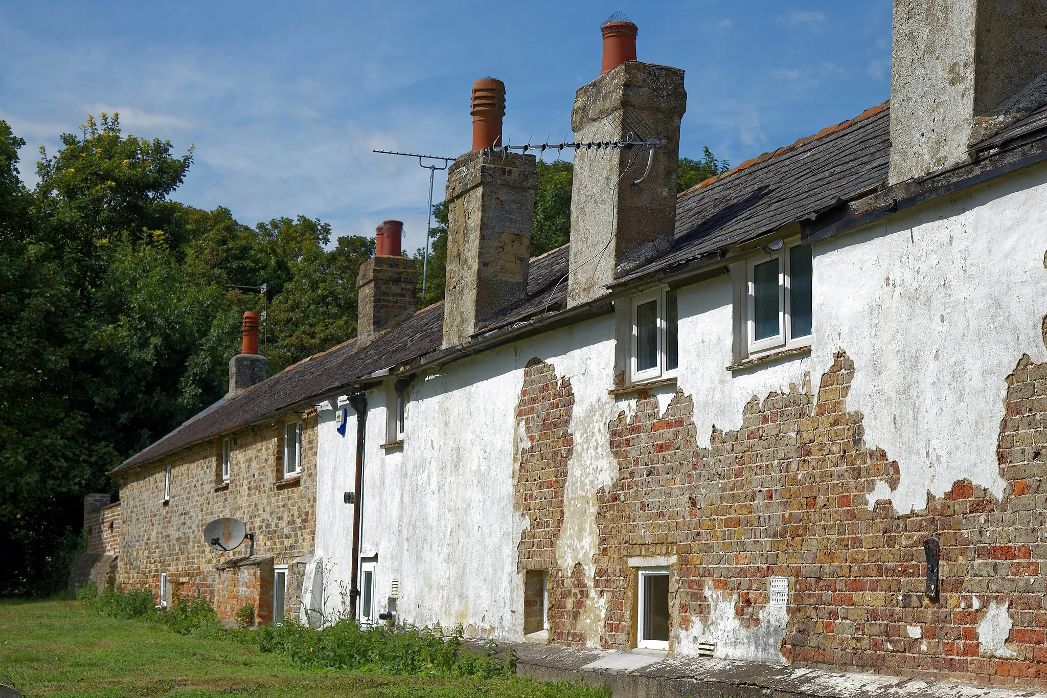 Photo showing: A row of cottages backing on to the churchyard of St Mary Magdalene's Church in Monkton, Kent, England. Camera: Canon EOS 6D with Canon EF 24-105mm F4L IS USM lens. Software: RAW file lens-corrected, optimized, perhaps cropped, and converted to JPEG with DxO OpticsPro 11 Elite, and likely further optimized with Adobe Photoshop CS2.