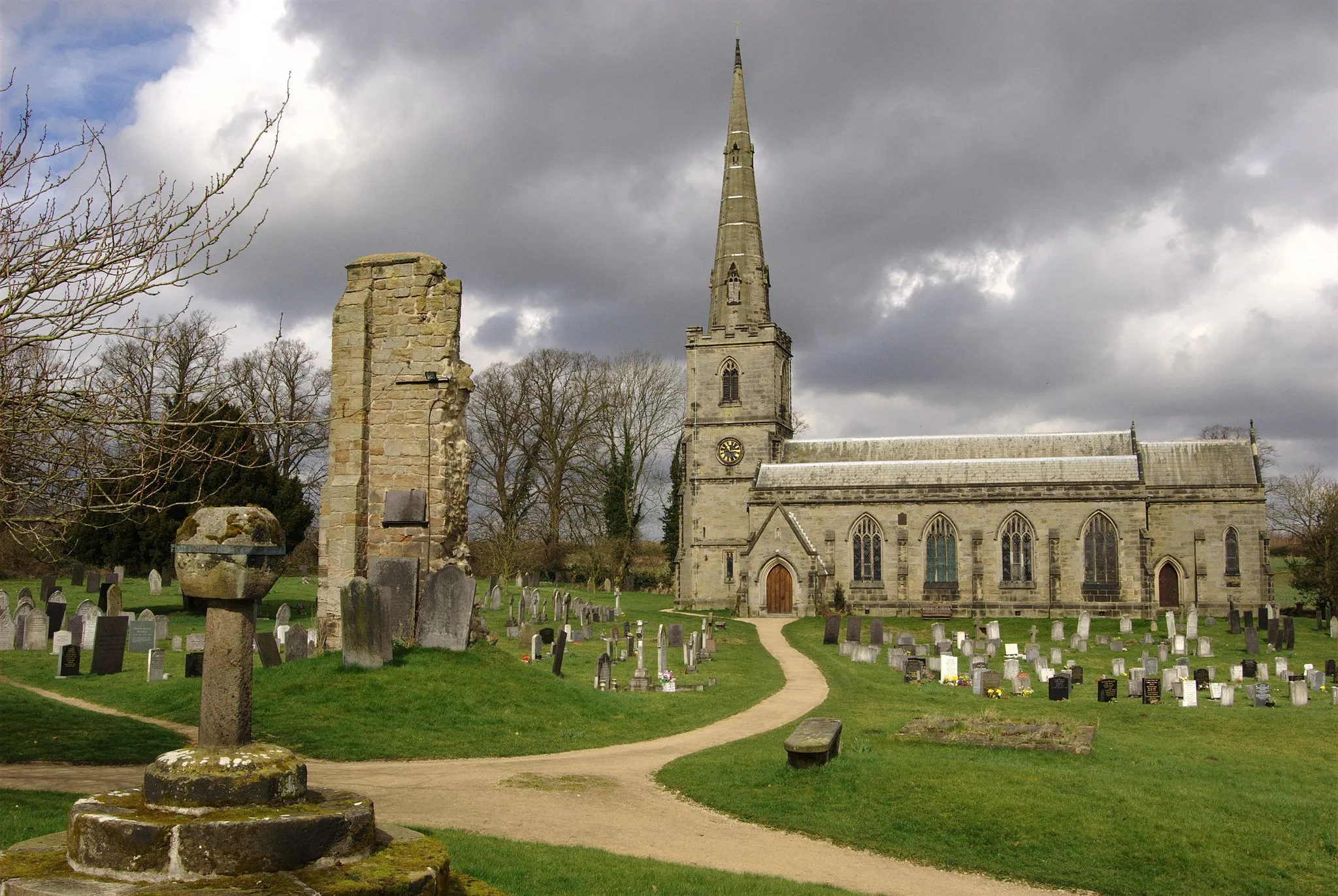 Photo showing: St George's parish church, Ticknall, Derbyshire, seen from the south. On the left in the foreground is the truncated Medieval churchyard cross. Centre left between the cross and St George's church is the ruin of the tower of the Medieval church of St Thomas Becket. St Thomas Becket's was demolished when St George's was built.