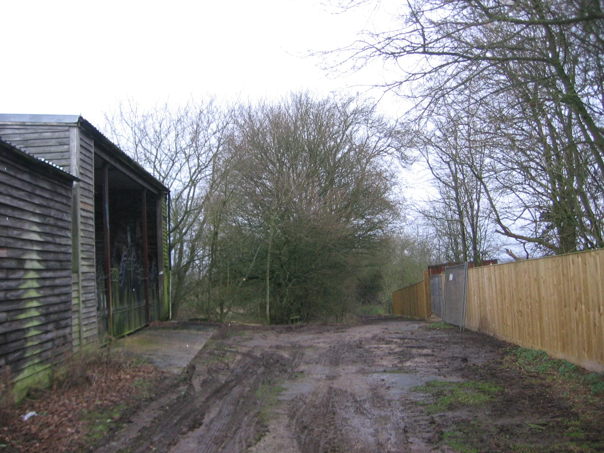 Photo showing: A muddy path and a garage with elaborate gates