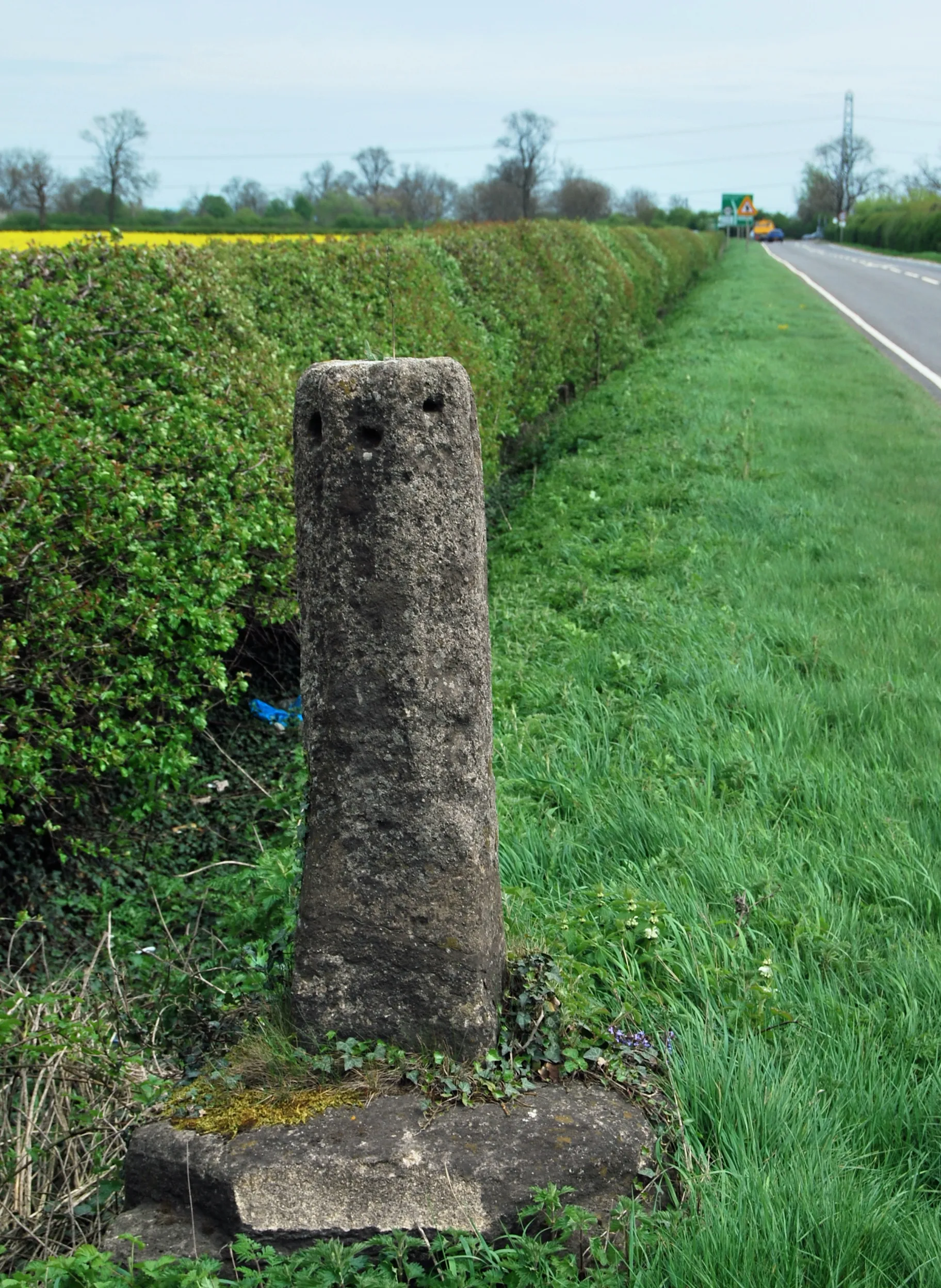 Photo showing: Base and broken shaft of a Mediæval stone cross beside the A607 road south of Frisby on the Wreake, Leicestershire