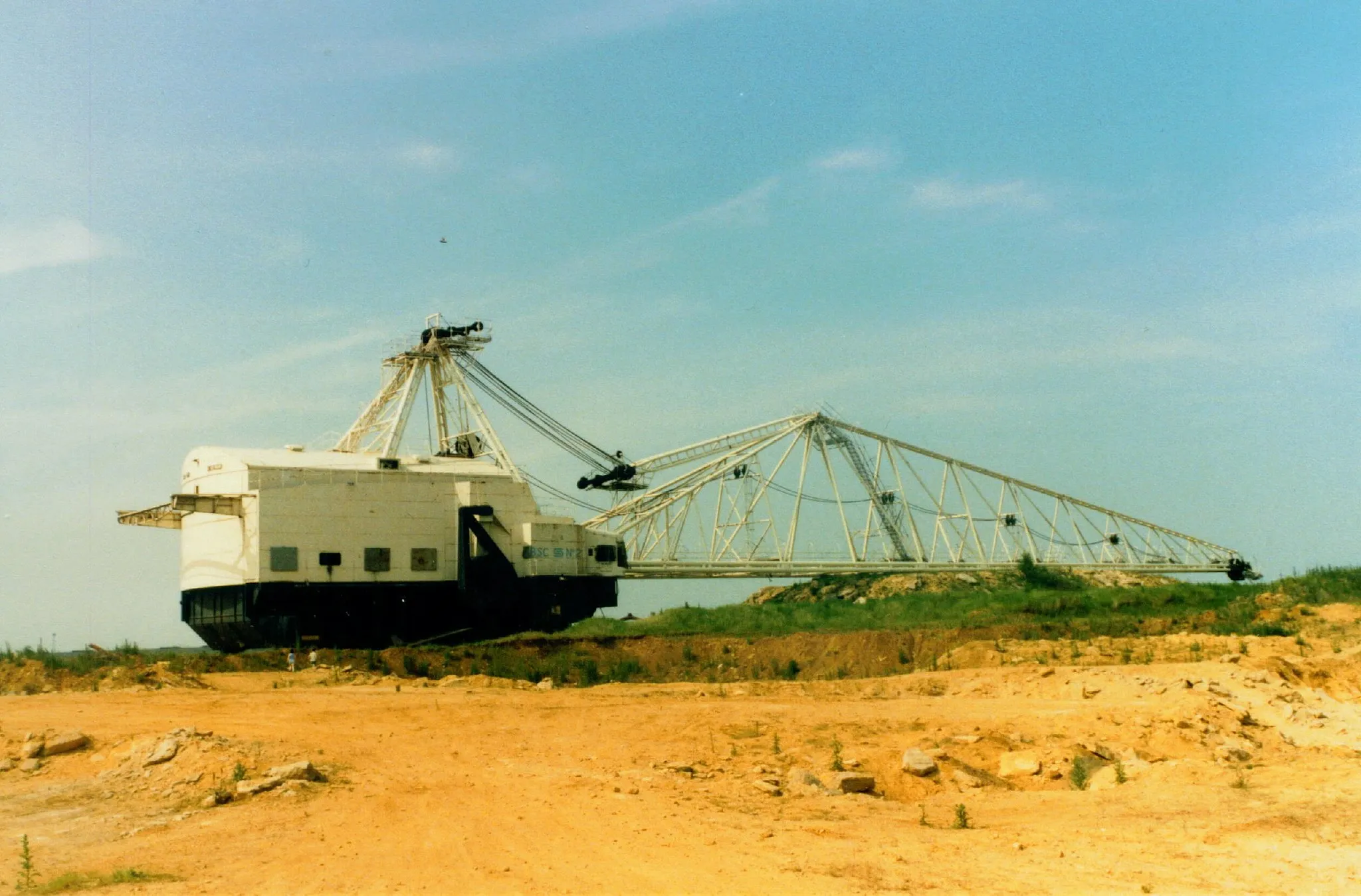 Photo showing: This picture shows a large walking dragline which operated in the UK between the 1950s and 1980s.
The picture was taken in ~July/August 1986 by Mr D King.
For an idea of scale, the photographer's children, aged around six and ten at the time of capture, can be seen standing in front of the machine towards its rear.

This picture is of W1400 N`2 which worked Cowthick quarry oppsite the steelworks next to Weldon.  Although similar to Sundew, the boom is 26ft longer and over 200 tons of pig iron ballast were used to balance this legthened boom.