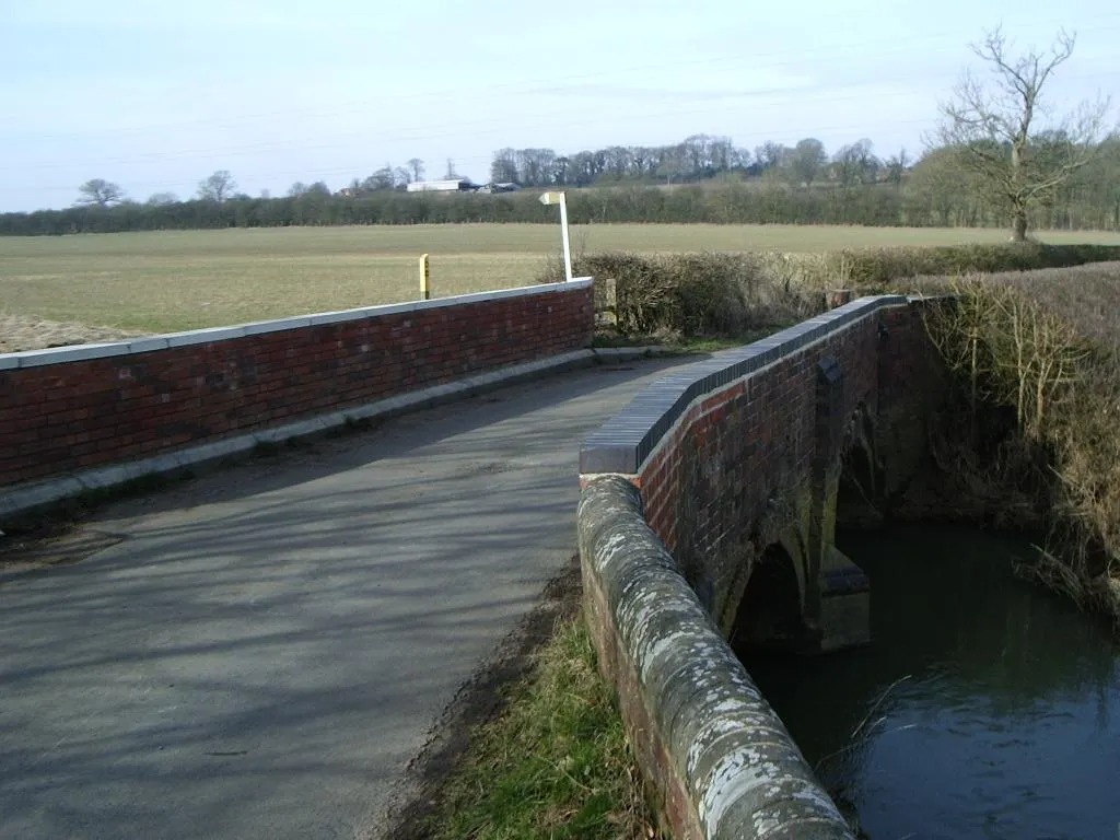 Photo showing: Bridge over River Avon, Lilbourne River bridge across Station Road, Lilbourne.  Catthorpe and farms in background.