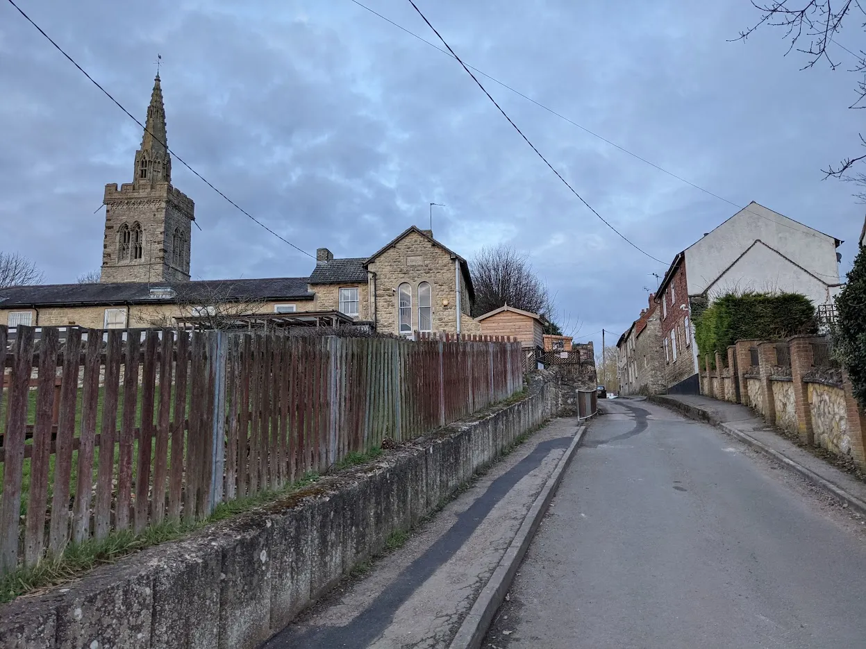 Photo showing: View up a small lane in the English village of Wymington that leads to a row of cottages, the school, and the church.