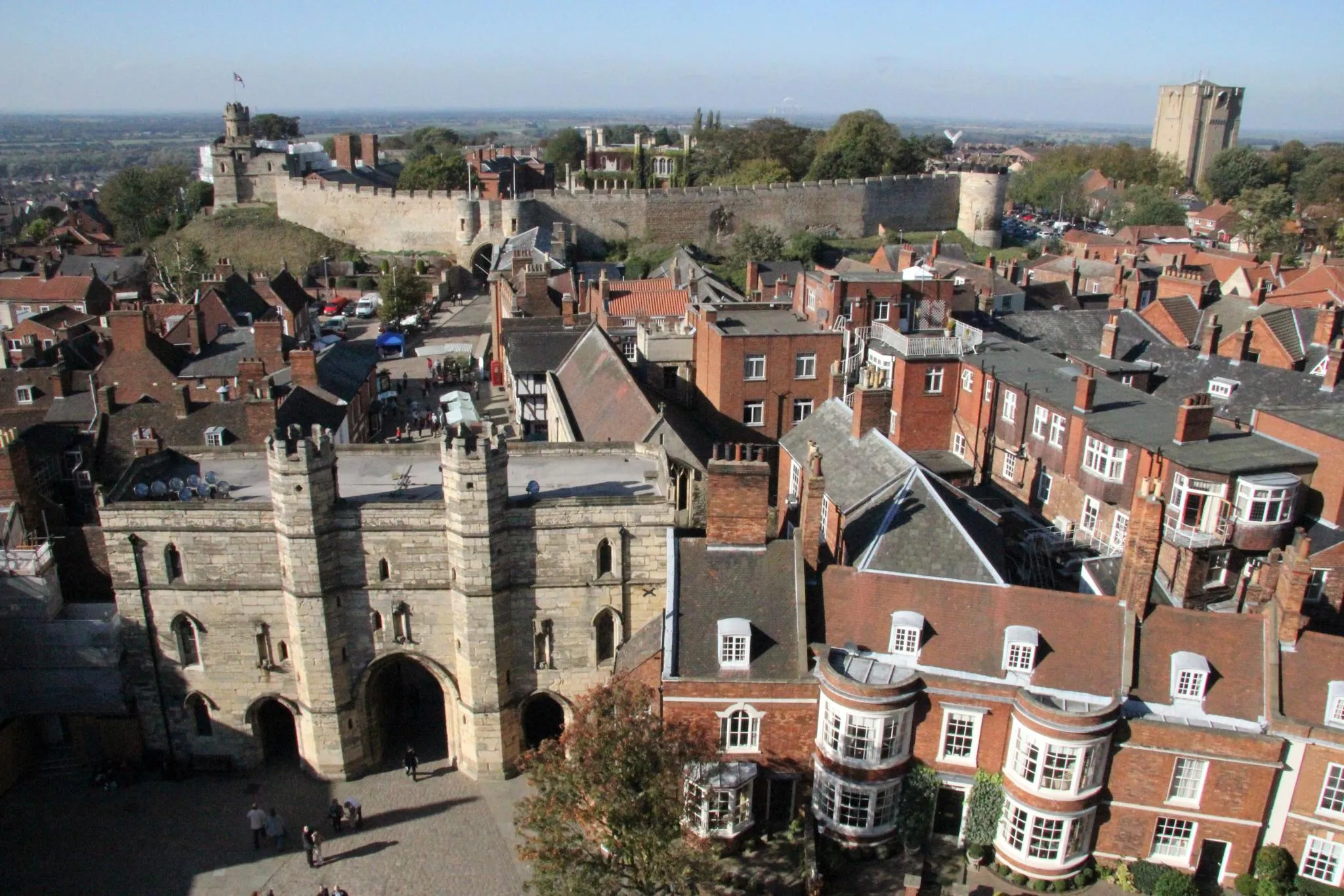 Photo showing: The view west from Lincoln Cathedral. The camera is pointing at the medieval castle. On the left hand side of the castle the 'Lucy Tower' on top of one of the castle's two keeps can be seen. To the right of that the the east gatehouse, and two towers can be seen further to the right.