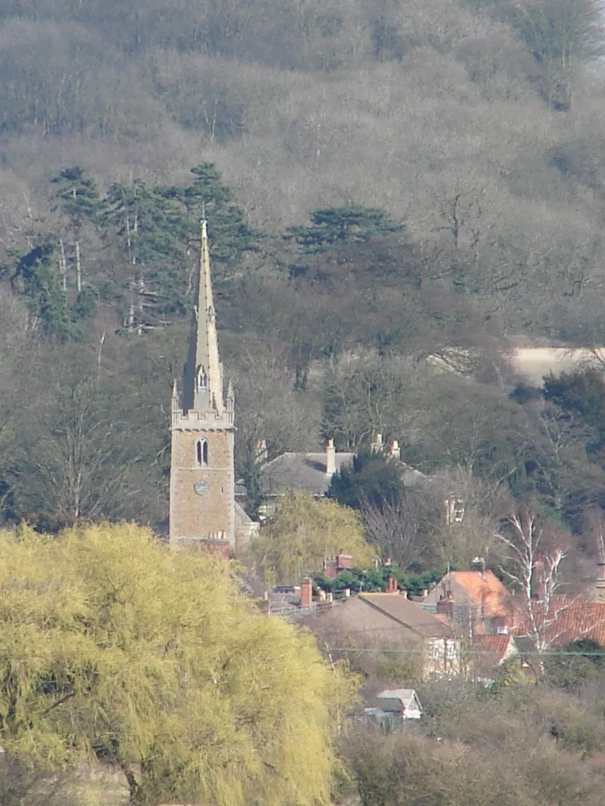 Photo showing: St Nicholas Church, Barkston Long view from the west of the village where the spring sunshine picks out the spire of the church against the backdrop of trees on the hills.