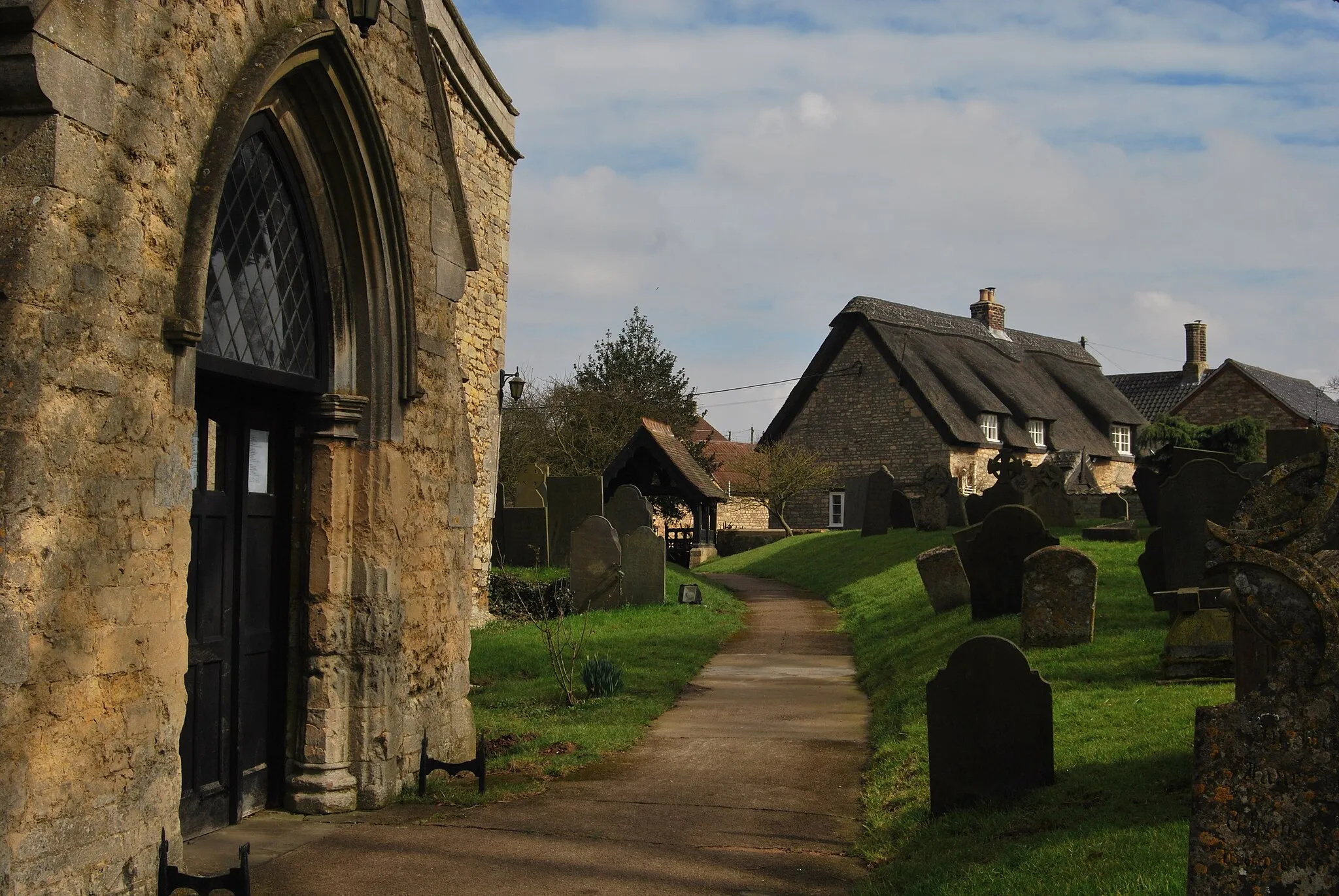 Photo showing: Waltham on the Wolds, Vale of Belvoir, Leicestershire. St Mary Magdalene Churchyard with cottages.