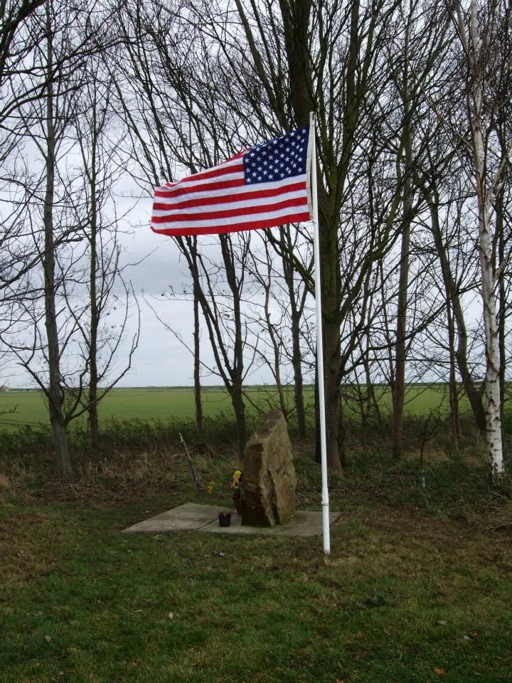 Photo showing: The Stars and Stripes flies proudly over a memorial near Thorney Hill, England to the airmen who perished when their C-141 transport crashed during a thunderstorm in August 1976. A JAC team led by Master Sgt. Charles W. Hajny cleaned the site and replaced the tattered American flag with a new one.