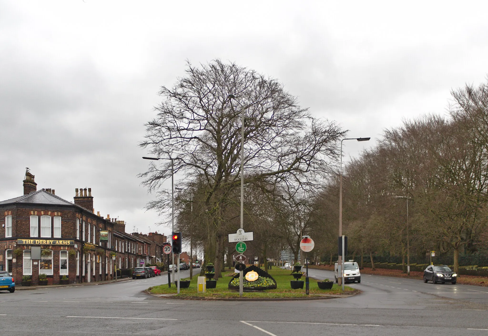 Photo showing: Major junction of five roads at the southwest corner of Woolton, Liverpool. Derby Arms to the left, on the corner of Vale Road. District and other signs in the centre.