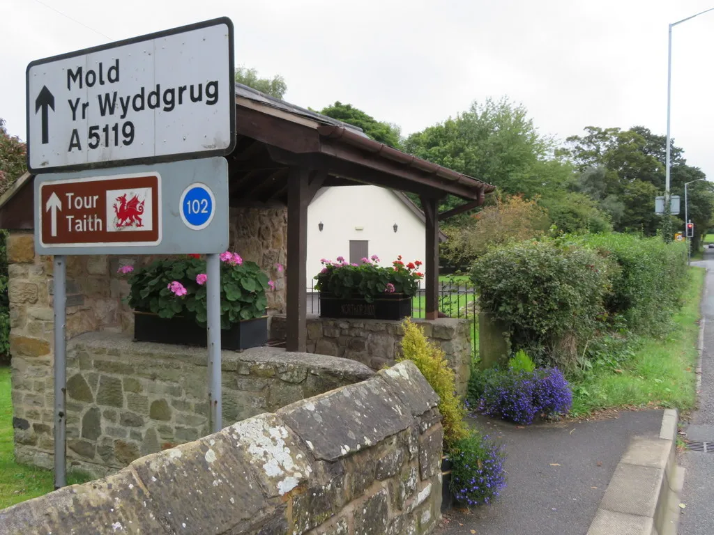 Photo showing: Bus shelter and a stone in the hedge in Northop