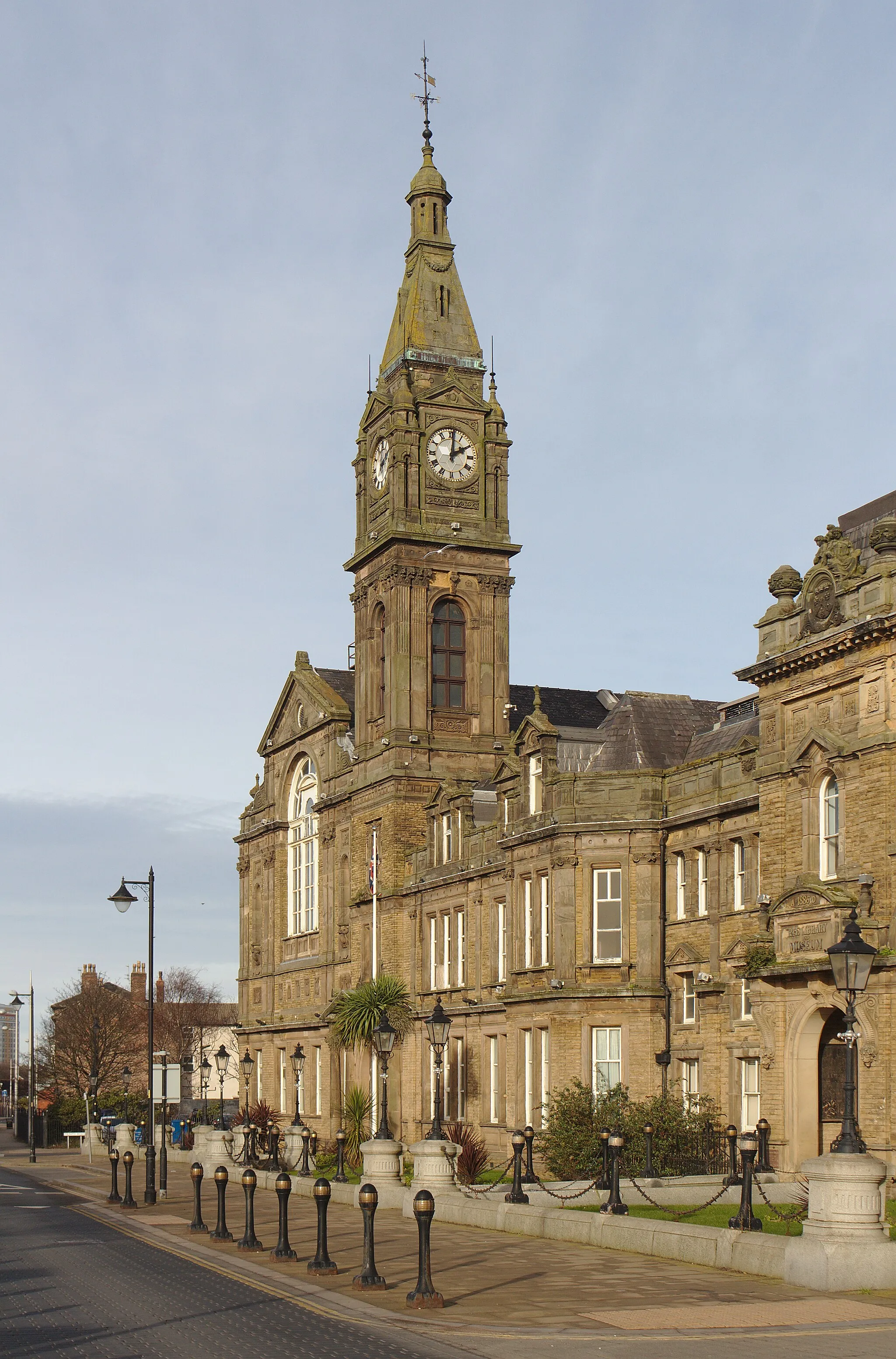 Photo showing: View along the front elevation, highlighting the clock tower.