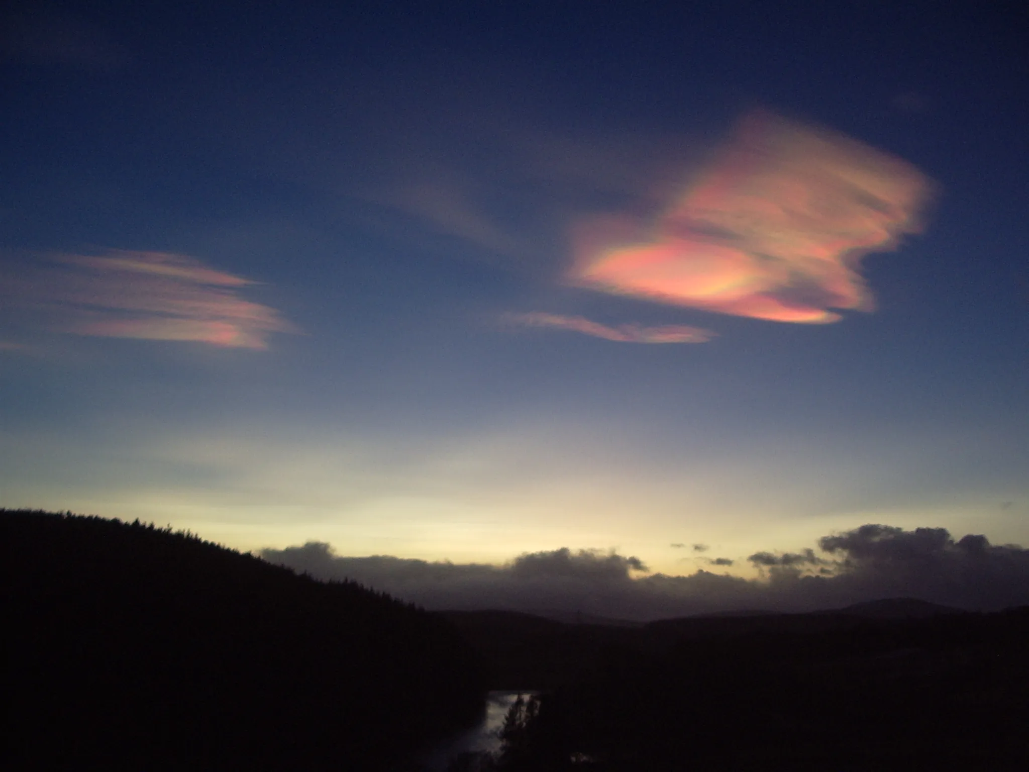 Photo showing: Nacreous clouds, Aberdeenshire, UK. 9 December 2012. Taken 16:05 9 December 2012. About 30 minutes after sunset looking south-west. The sun would have set at 15:27 above the left bank of the river and would have been about 5 degrees below the horizon when the photo was taken. Almanac: http://www.esrl.noaa.gov/gmd/grad/solcalc/ The camera time was 25 minutes fast.