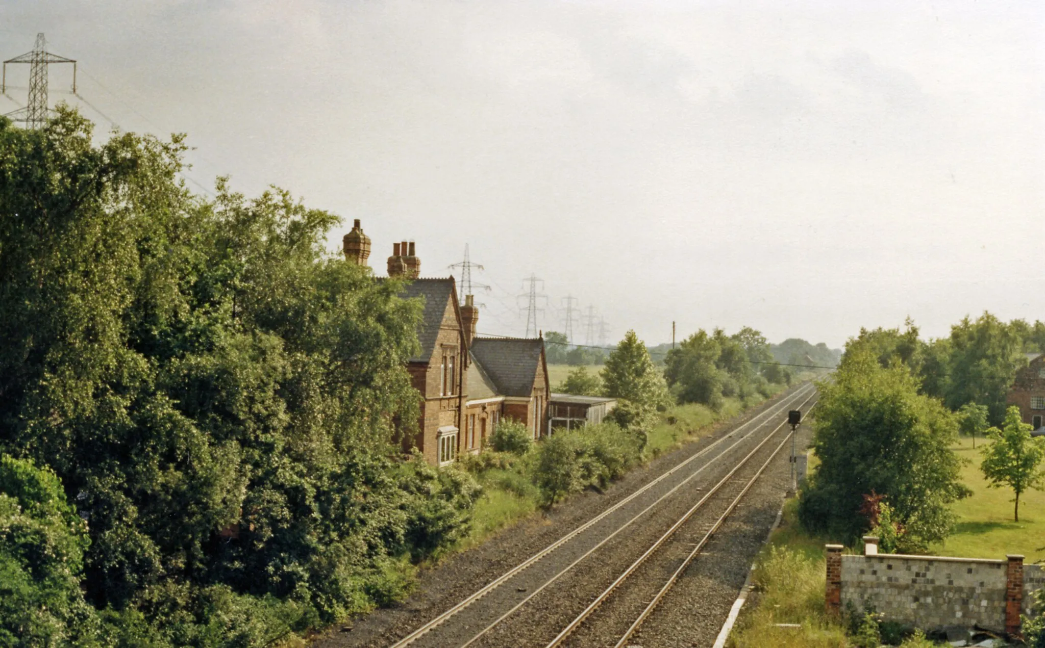 Photo showing: Carlton (Towers) station (remains), 1988.
View SW, towards Wrangbrook Junction, Cudworth etc.: ex-Hull & Barnsley Railway Hull - Cudworth/Denaby/Wath line. The latter-day (1885 - 1902) H&B system was built primarily to carry coal from South Yorkshire mines to Hull. Carlton (originally Carlton Towers) station was closed to passengers when services were withdrawn west of South Howden as early as 1/1/32 and to goods from 6/4/59, but mineral traffic continued to pass through until the line closed completely from 7/8/67. The line here is in use because in 1972 the section from Hensall to Drax was restored for use by Merry-Go-Round coal trains serving Drax Power Station.