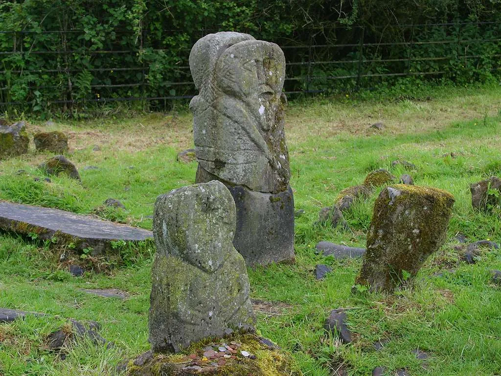 Photo showing: The Janus and Lustymore figures on Boa Island, Co. Fermanagh, Northern Ireland. The Janus figure is in the background, the Lustymore figure in the foreground.