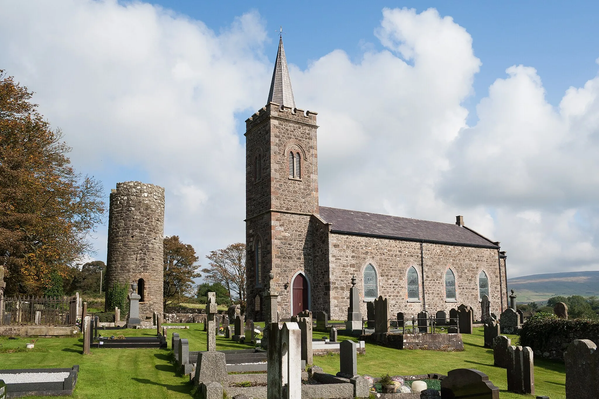 Photo showing: Surviving remains of the round tower and modern church at Armoy in the townland Glebe. This is recorded as a scheduled monument SMR Number ANT 013:010.