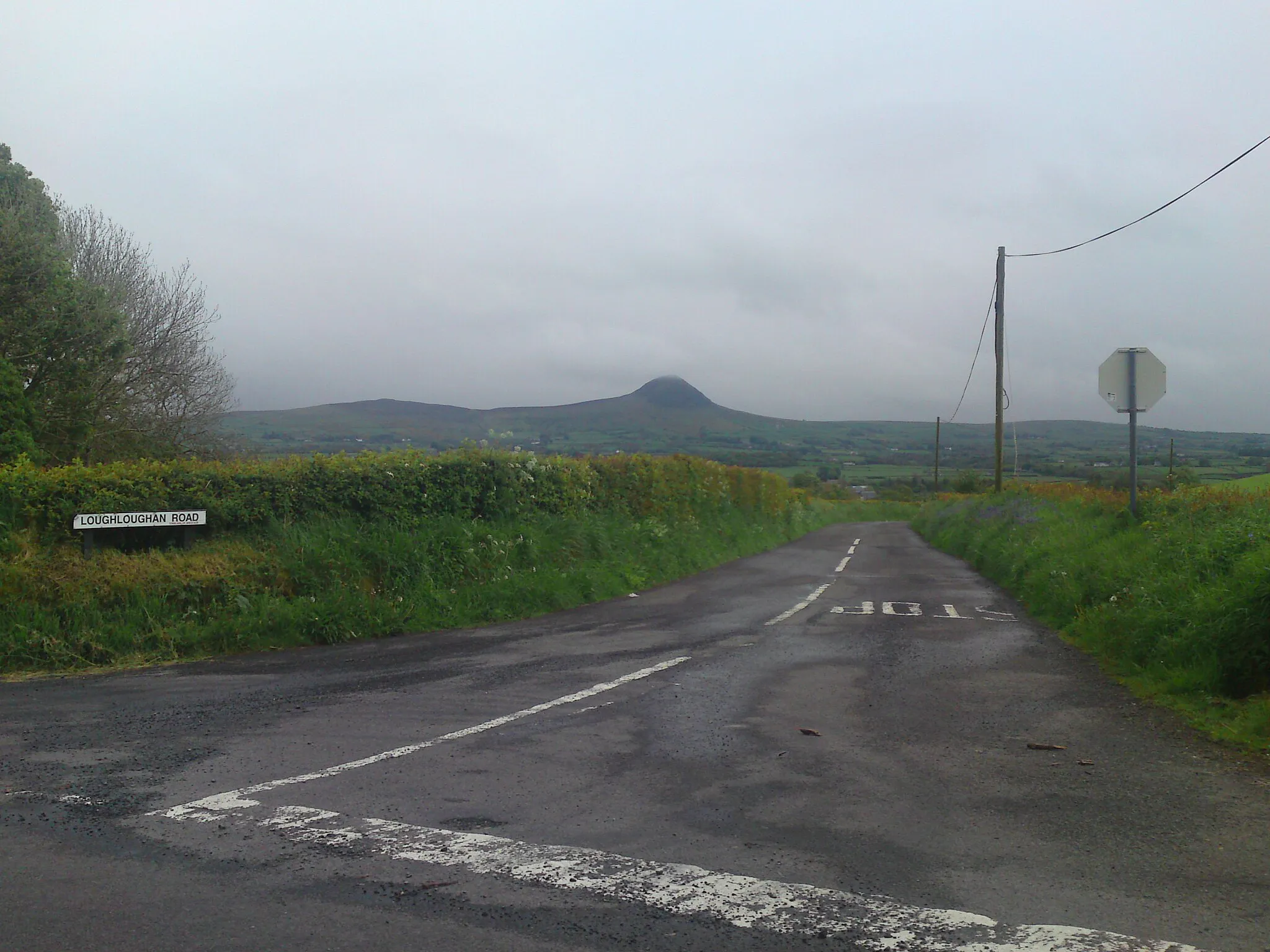 Photo showing: A view of Loughloughan Road from the Longmore Road looking across at Slemish Mountain outside Aughafatten County Antrim.