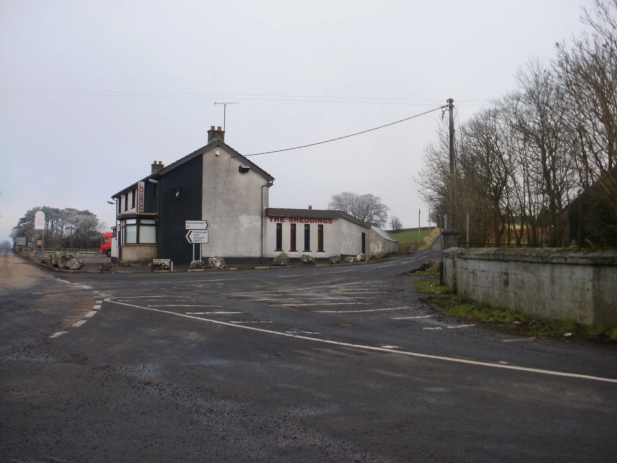 Photo showing: Lisles Hill Road off the Carnlough Road in Aughafatten.The building beside it is the now closed Sheddings public house.