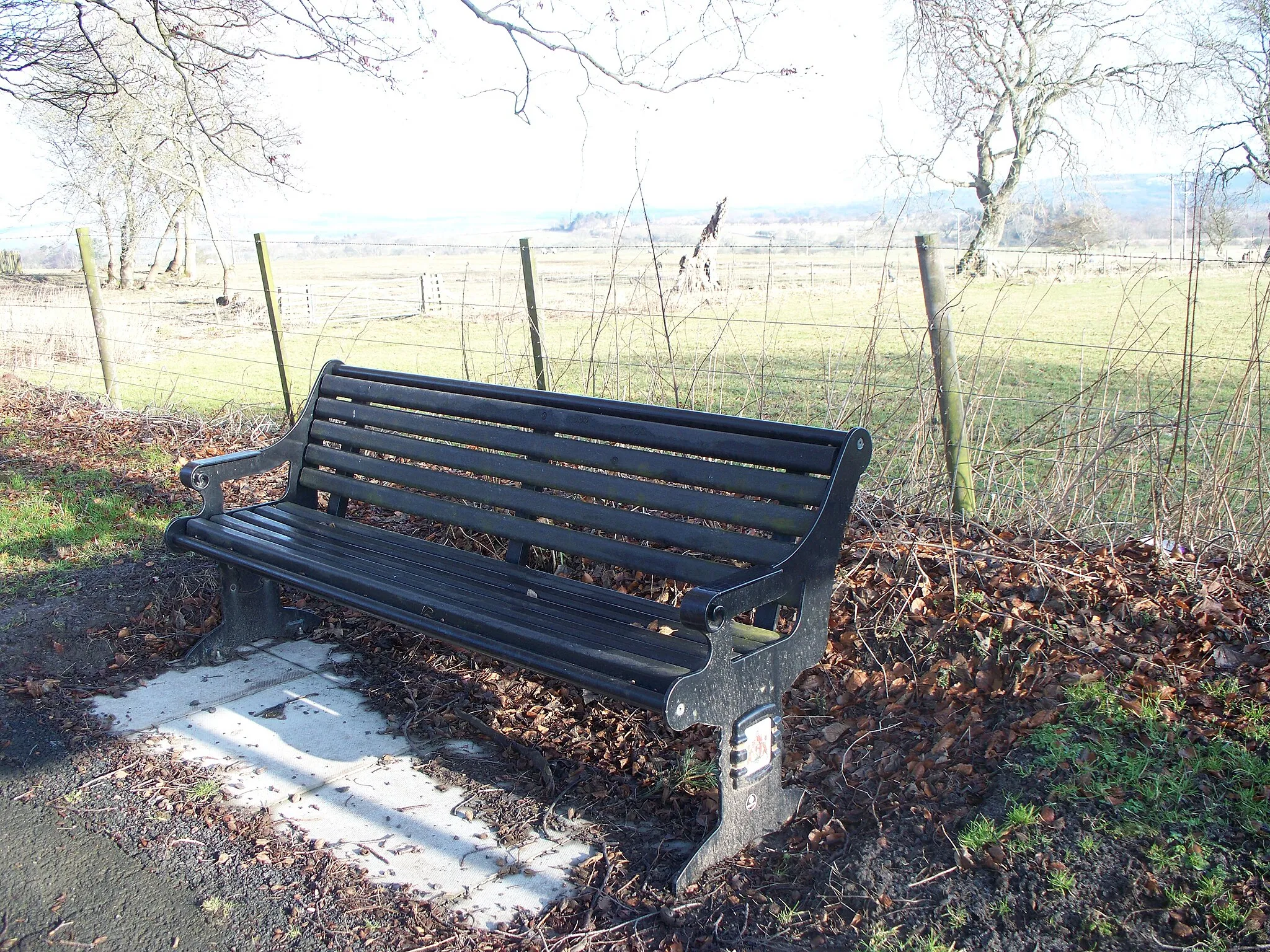 Photo showing: A seat By the side of The A697. Chester hill is the green bit which is in the bright light beyond.
Interestingly the seat is made from re-cycled plastic, it is made to look like a traditional park bench and should withstand the weather longer than more traditional materials.