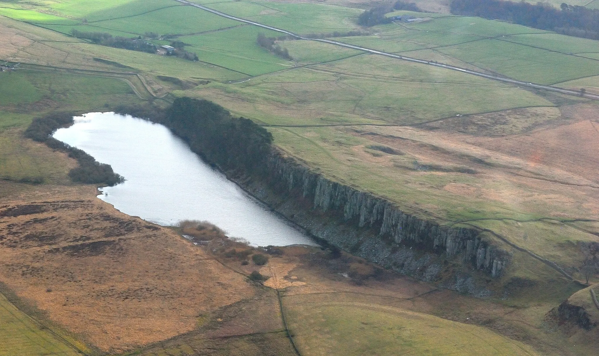 Photo showing: Aerial photograph of Crag Lough, Northumberland, England, with a section of Hadrian's Wall between Milecastle 37 (extreme left) and the Sycamore Gap (lower right, with the leafless Sycamore Gap tree on the edge of the picture). Nikon D60 f=55mm f/10 at 1/400s ISO 800. Processed using Nikon ViewNX 2.1.2 and GIMP 2.6.11.