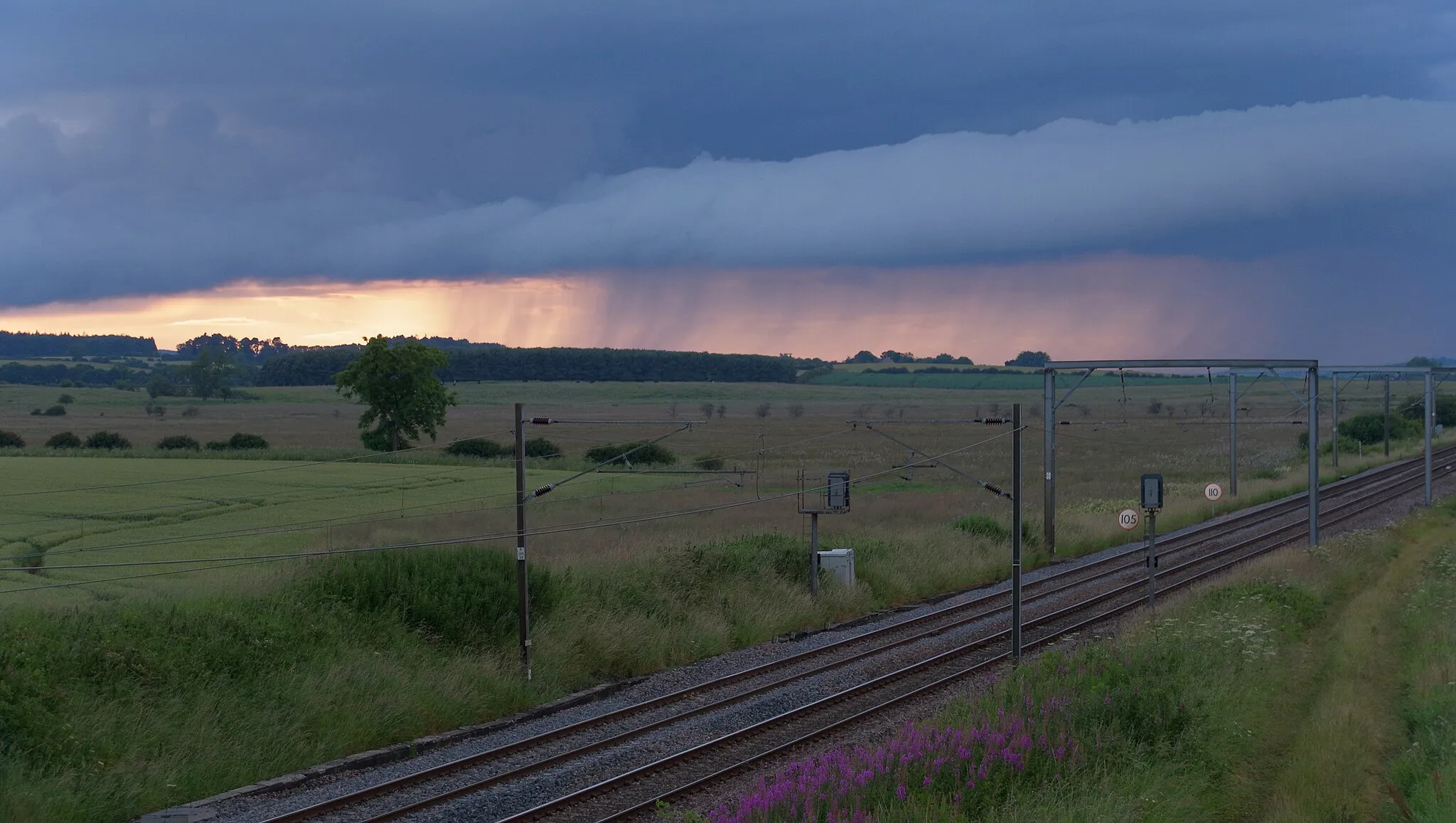 Photo showing: The East Coast Main Line near Newham in Northumberland, looking north towards a rainstorm.