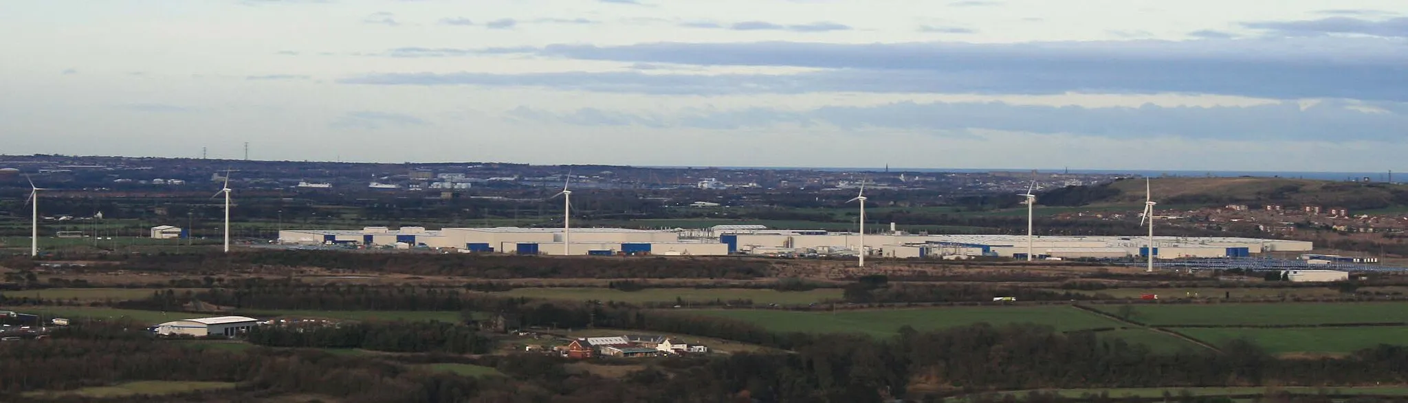 Photo showing: Nissan Motor Manufacturing UK Ltd in Sunderland, UK. Factory complex, including wind turbines, taken from Penshaw Monument.