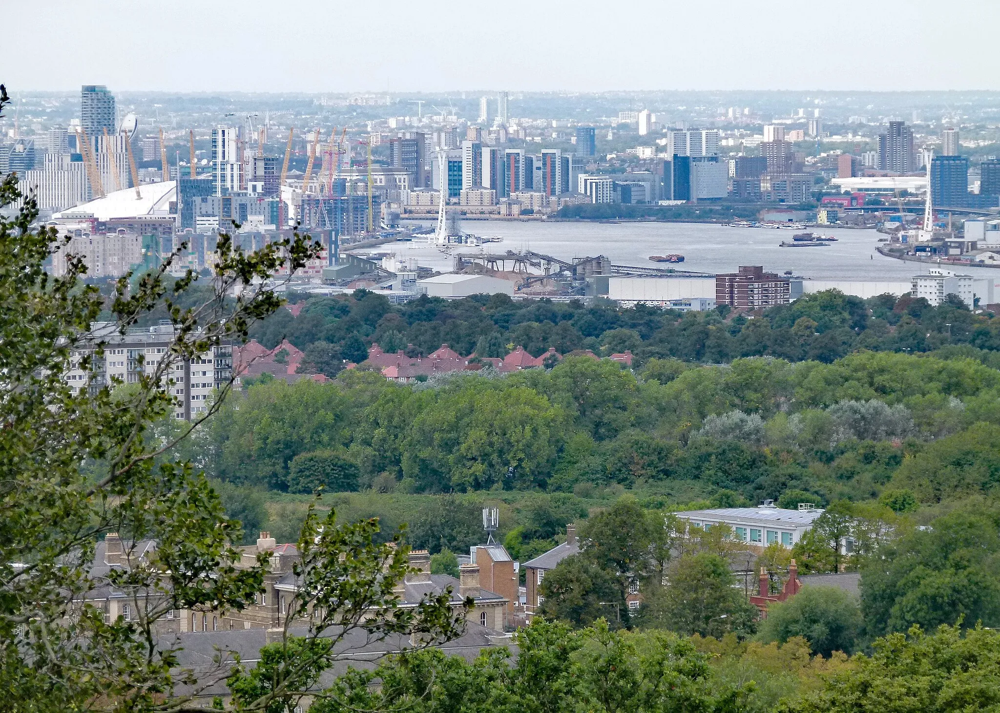 Photo showing: View towards the northwest from the top of Severndroog Castle, Shooters Hill, South east London, UK. Foreground left: Herbert Hospital. Centre: Woolwich Common, Charlton Riverside and river Thames. Background left: Greenwich Peninsula.