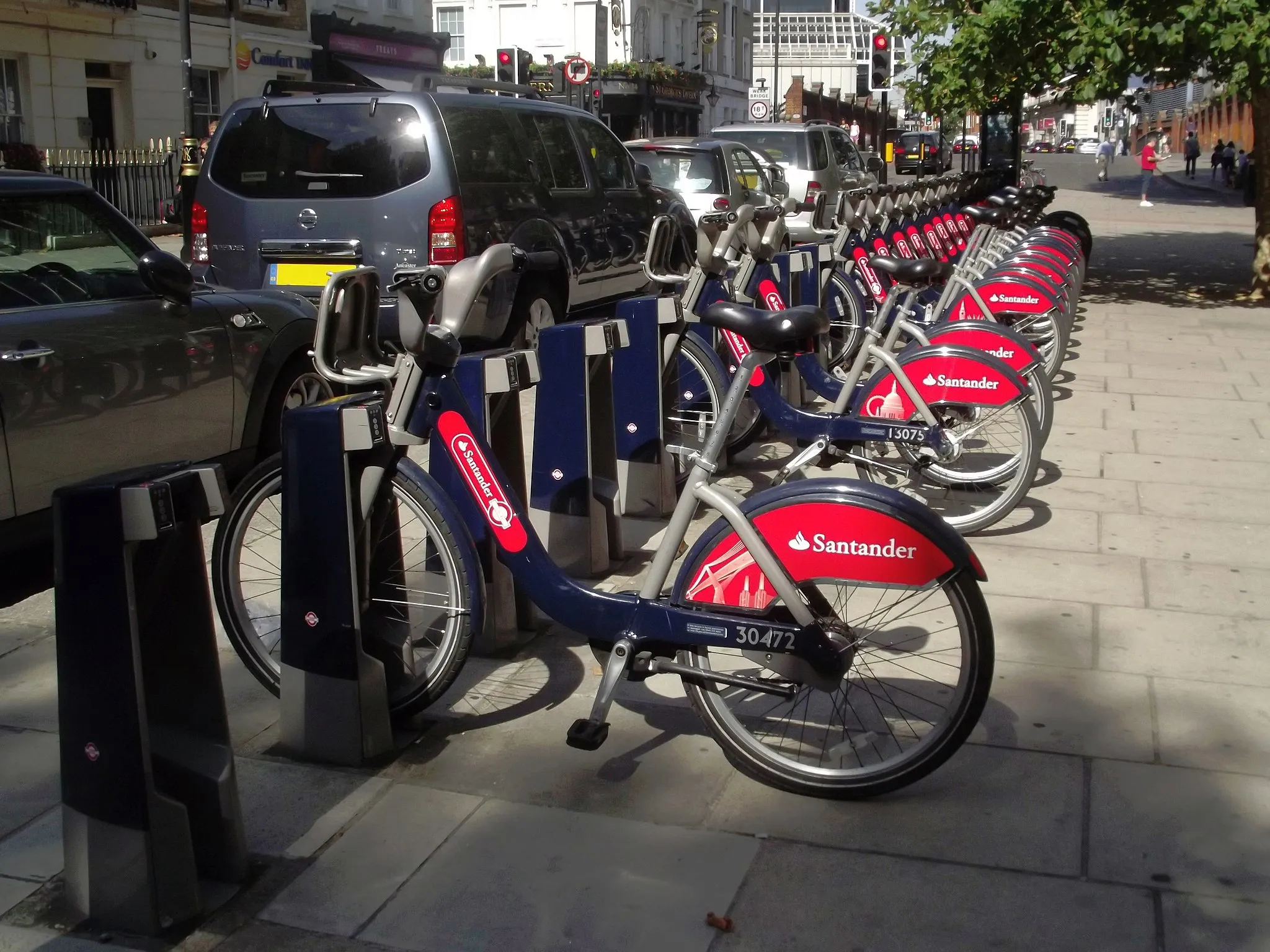 Photo showing: In Victoria, London. The area close to London Victoria Station.
Seen on Belgrave Road.
Boris Bikes seen on Belgrave Road. They are actually called Santander Cycles

The scheme started in 2010. Was sponsored by Barclays Bank from 2010 to March 2015, when they were known then as Barclays Cycle Hire. Santander took over the sponsorship from April 2015.