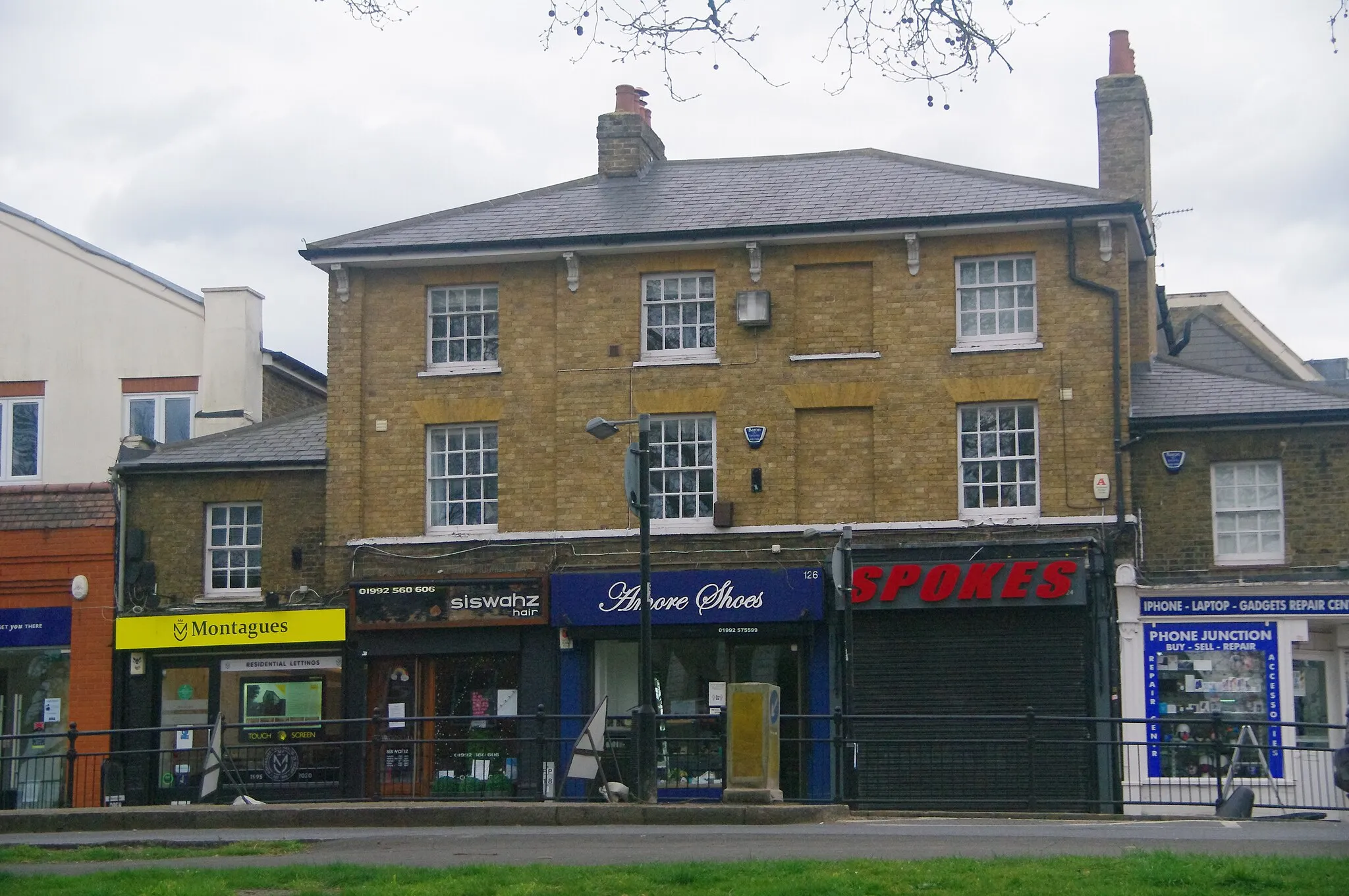 Photo showing: Shops on Epping High Street (6), Essex - April 2021 - showing Montagues estate agents, Siswahz hairdresssers, Amore shoe shop and Spokes cycle shop,