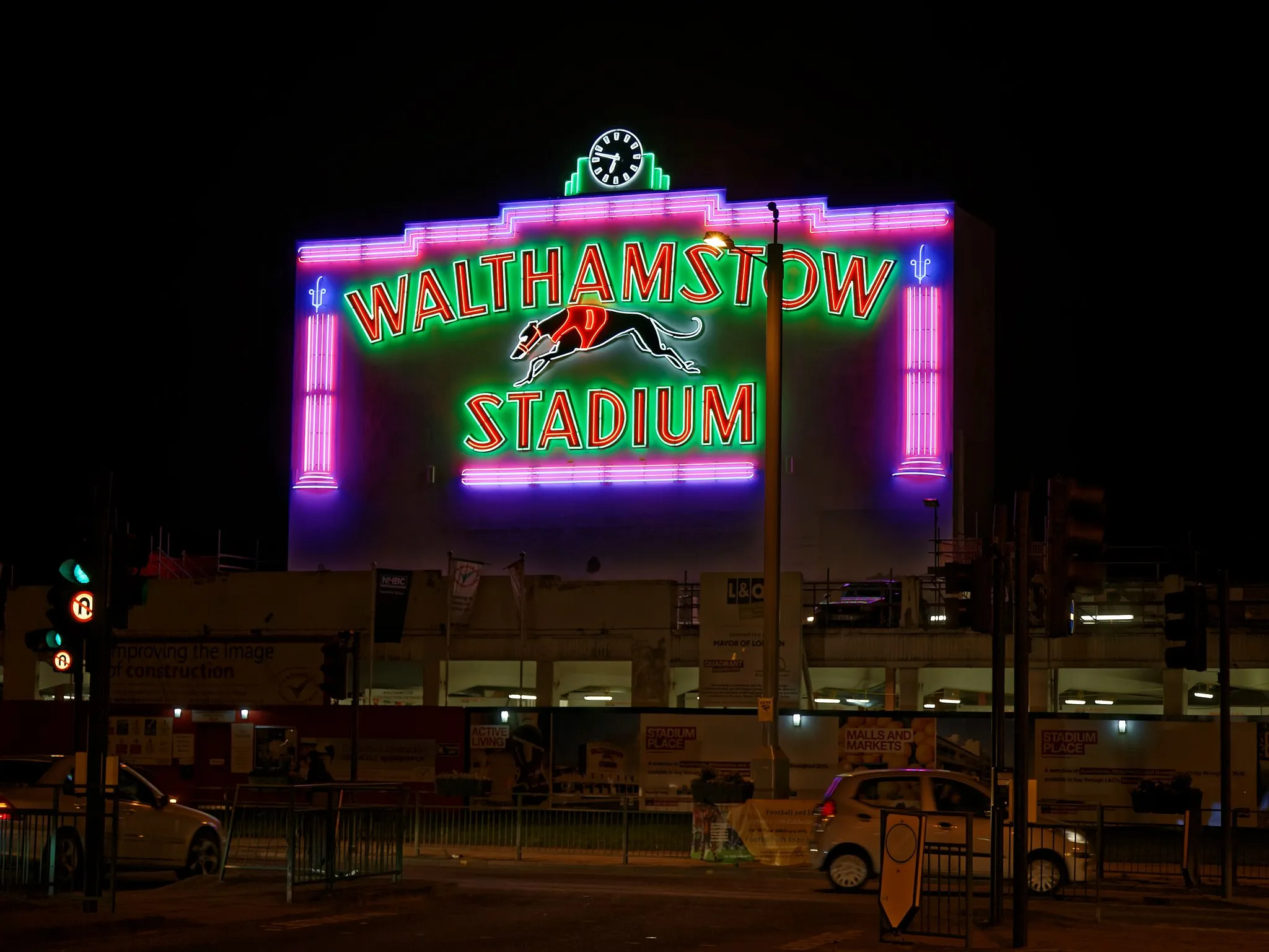 Photo showing: The February 2016 newly refurbished neon light frontage of the old Walthamstow Greyhound Stadium in the Borough of Waltham Forest, London. England. The greyhound stadium was closed in 2008, and has been redeveloped as 'Stadium Place,' and will include residential housing, markets and malls. The front range of the stadium, which includes the neon lighting, is Grade II listed. The photograph is taken from Walthamstow Avenue across the A12 Chingford Mount Road. Camera: Canon EOS 6D with Canon EF 24-105mm F4L IS USM lens. Software: large RAW file lens-corrected, optimized and downsized with DxO OpticsPro 10 Elite, Viewpoint 2.