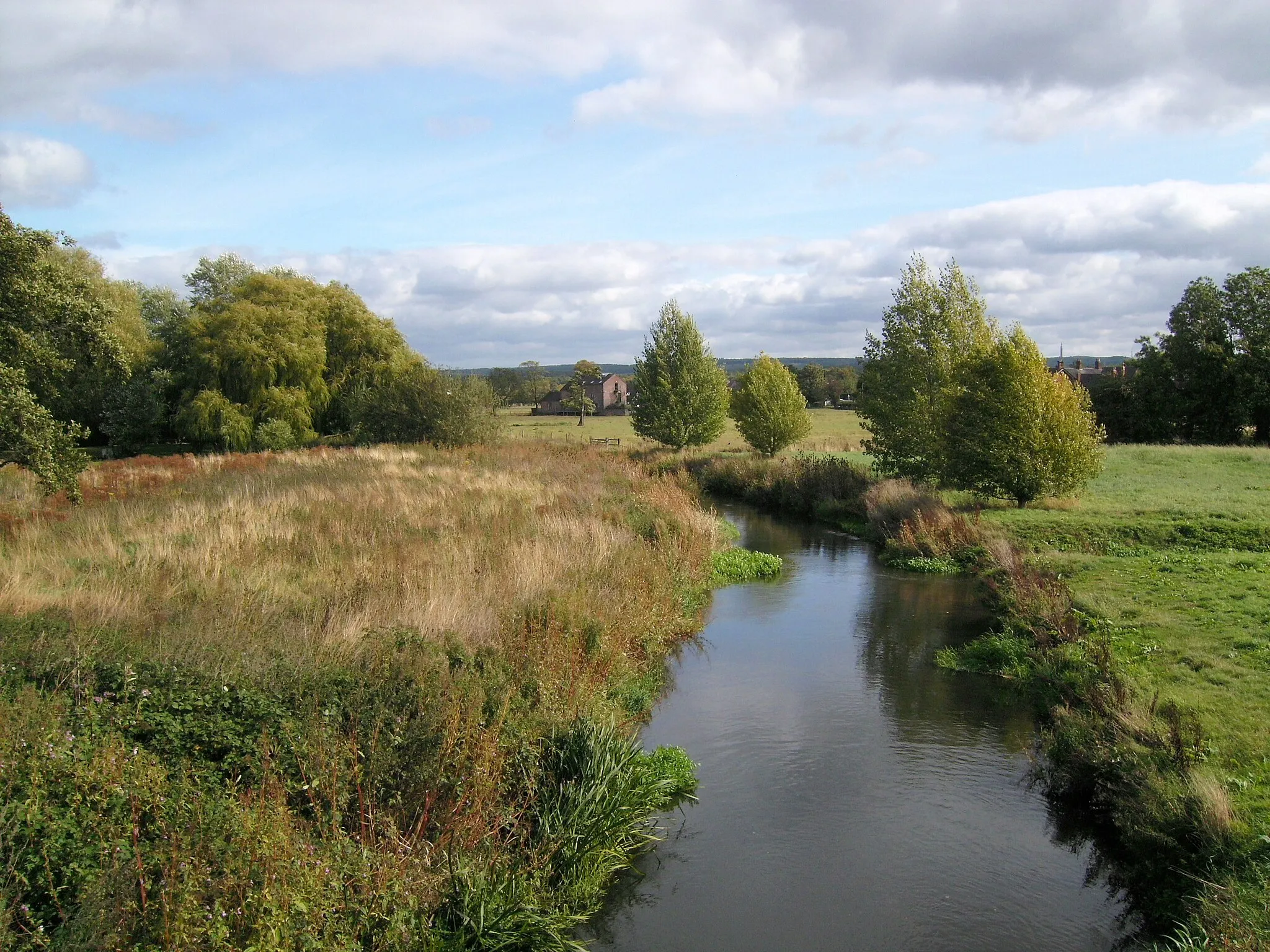 Photo showing: The River Penk, with Roller Mill in distance, from Bull Bridge, Penkridge, Staffordshire.