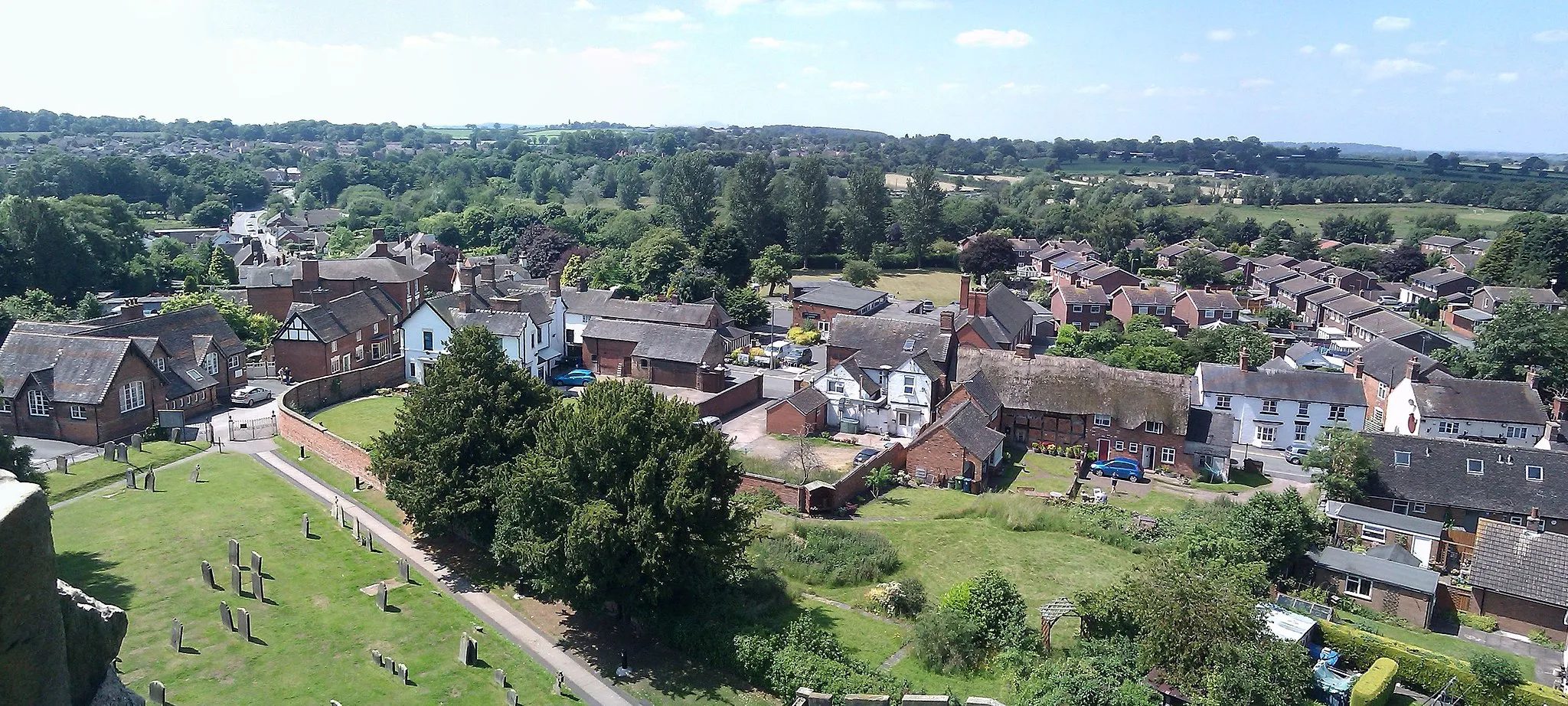 Photo showing: A view of Gnosall High Street and Gnosall Heath as seen from the top of the tower of St Lawrence's church.