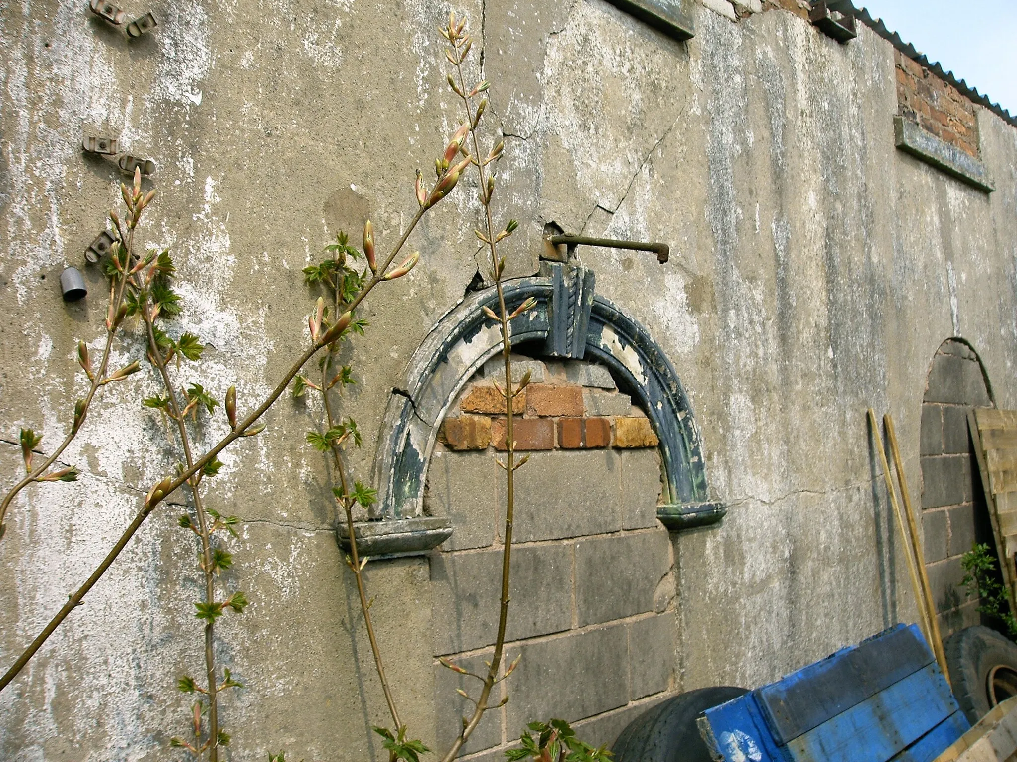 Photo showing: Harriseahead original Primitive Methodist Chapel built by Hugh Bourne (1802) now used as a work shed with only a few parts of the original walls remaining. The upper window sills may be seen.  The nearest arch, showing an architectural feature typical of Primitive Methodist Chapels, would have been a doorway. Harriseahead, Staffordshire.