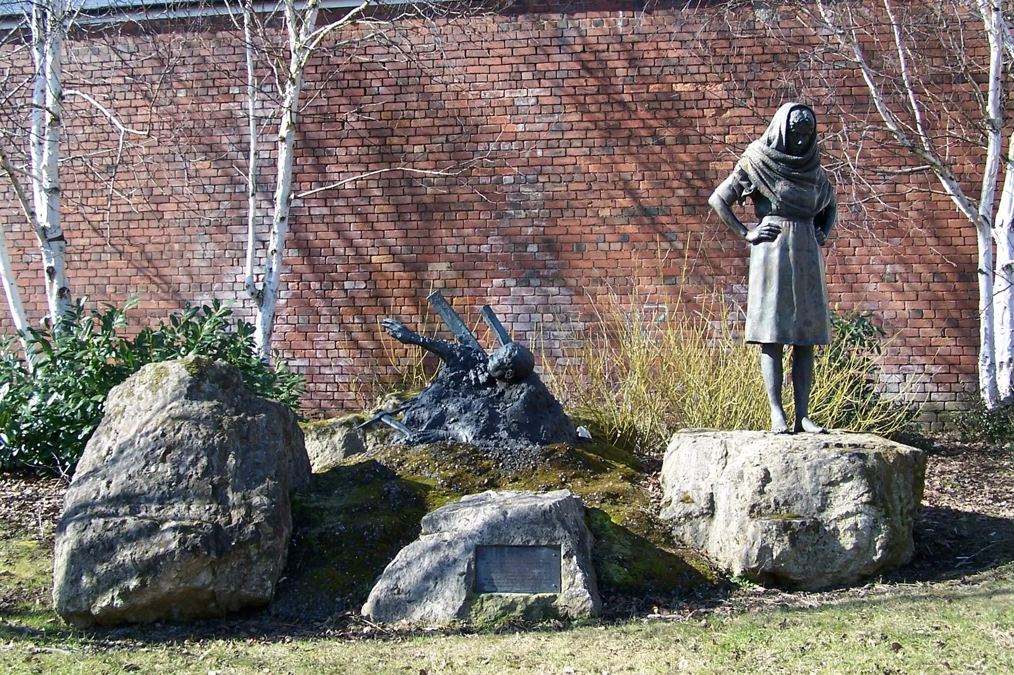 Photo showing: Miners' Memorial, Old Road, Conisbrough - 1. The Miners' Memorial just off Old Road, and next to the Library, is - and I quote from the Memorial Plaque - " A tribute to the Men and Boys who lost their lives at the Denaby & Cadeby Main Collieries from 1869 and to the women who shared their lives and suffered their loss."  The sculptor is Graham Ibbeson M.A.  R.C.A. and the Memorial was commissioned by the Doncaster Metropolitan Borough Council with the assistance of public arts and The Yorkshire Arts Association of 1987.  Graham Ibbeson has also sculpted the more famous statues of Eric Morecambe, sited at Morecambe ... and Les Dawson, sited at Lytham St Annes ... for more information follow ... http://www.grahamibbeson.co.uk/... For 'close-ups' of the figures see ... 1754970 1754975