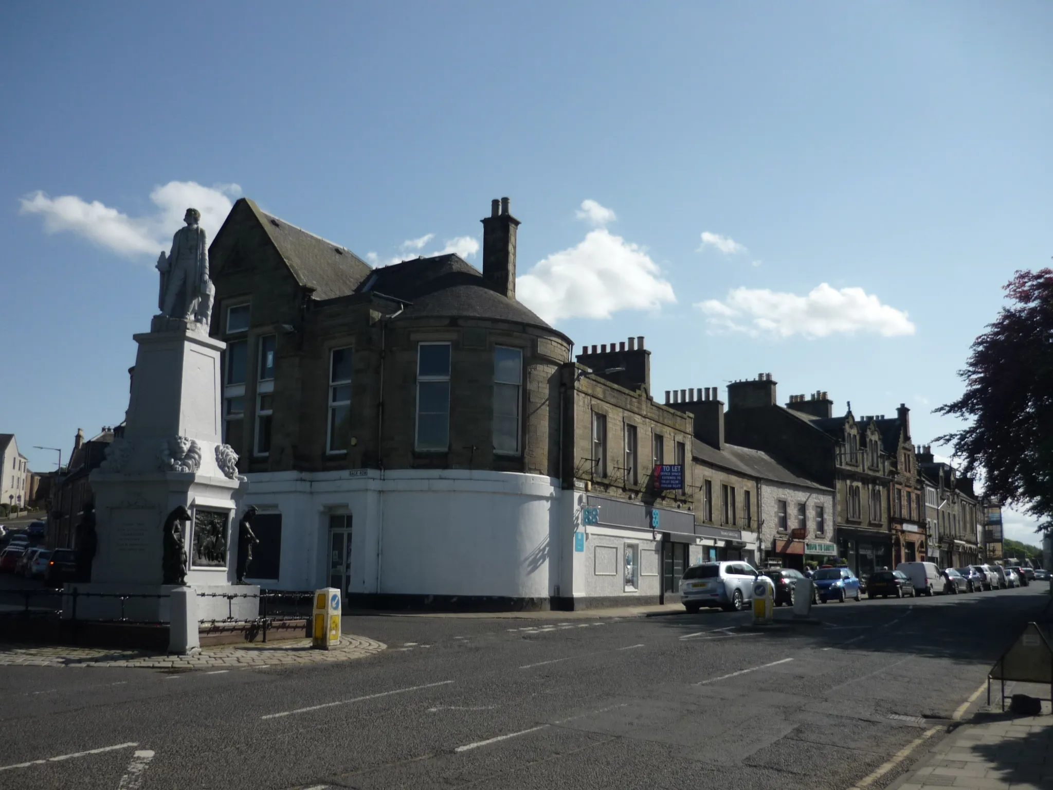 Photo showing: High Street, Selkirk looking south-west.  Back Row street to the left, and the monument to explorer Mungo PARK.  Selkirk, Scottish Borders, Scotland (May 2018).